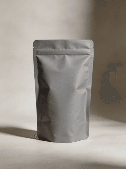 A matte gray, resealable stand-up pouch is centered against a neutral background, casting a soft shadow, conveying simplicity and modern minimalism.