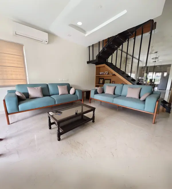 Pair of three‑seater blue upholstered sofas with wooden legs