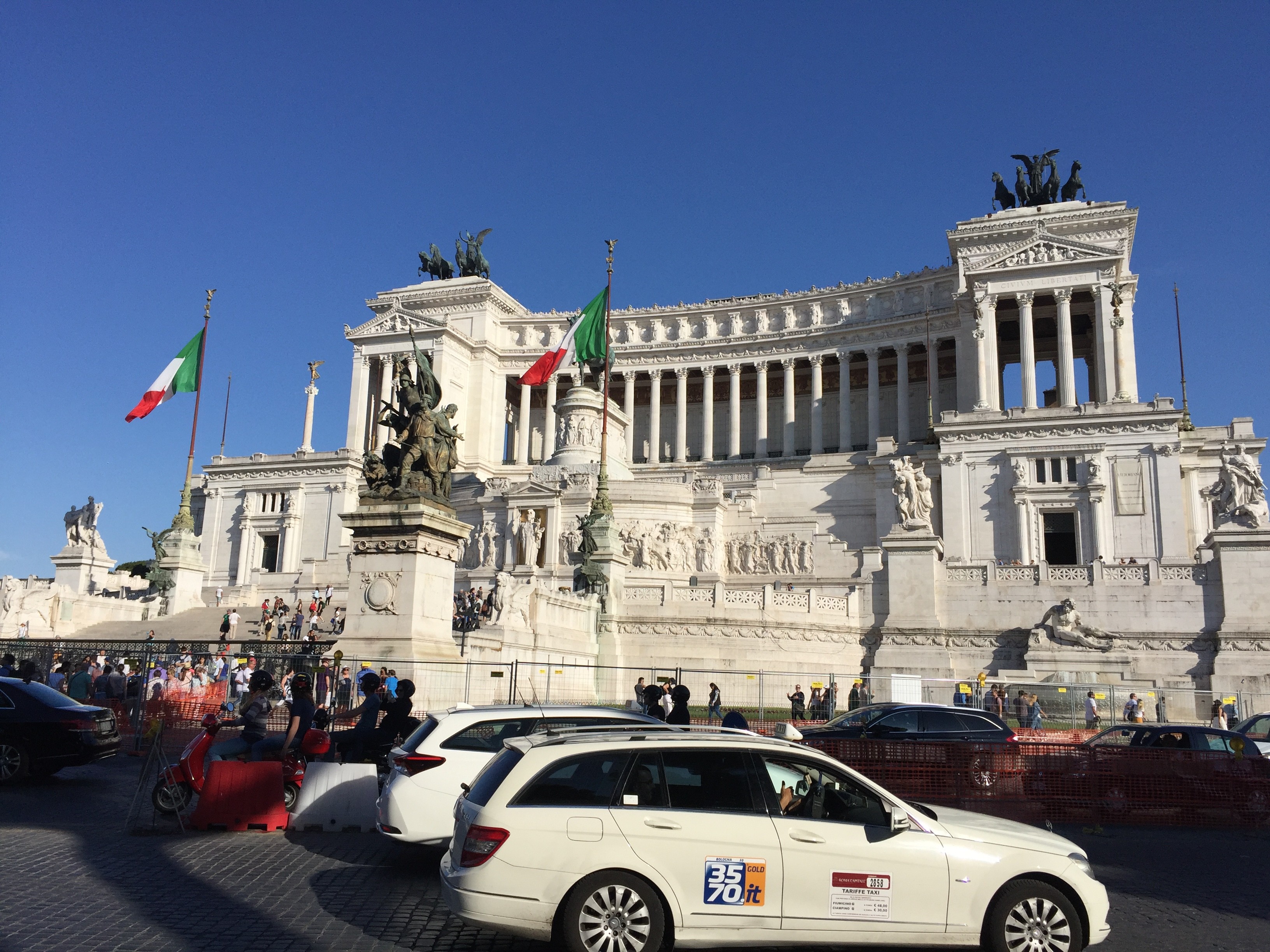 rome ancient building with taxis on front