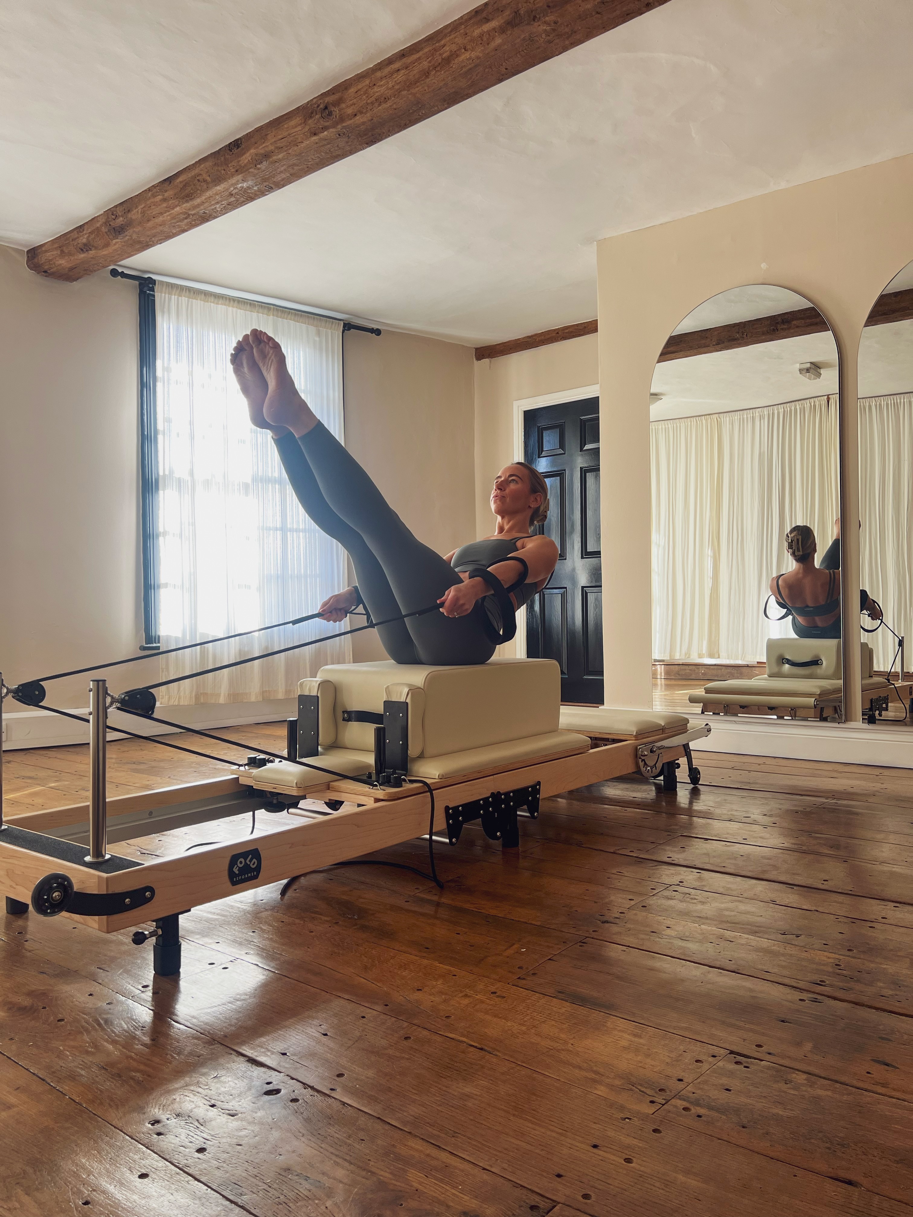 A row of houses in the background with a field and tree infront of them