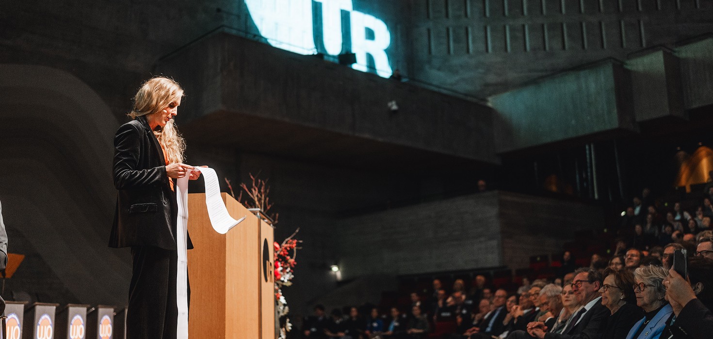 Caro Matzko steht vor einem Publikum und hält einen Vortrag.