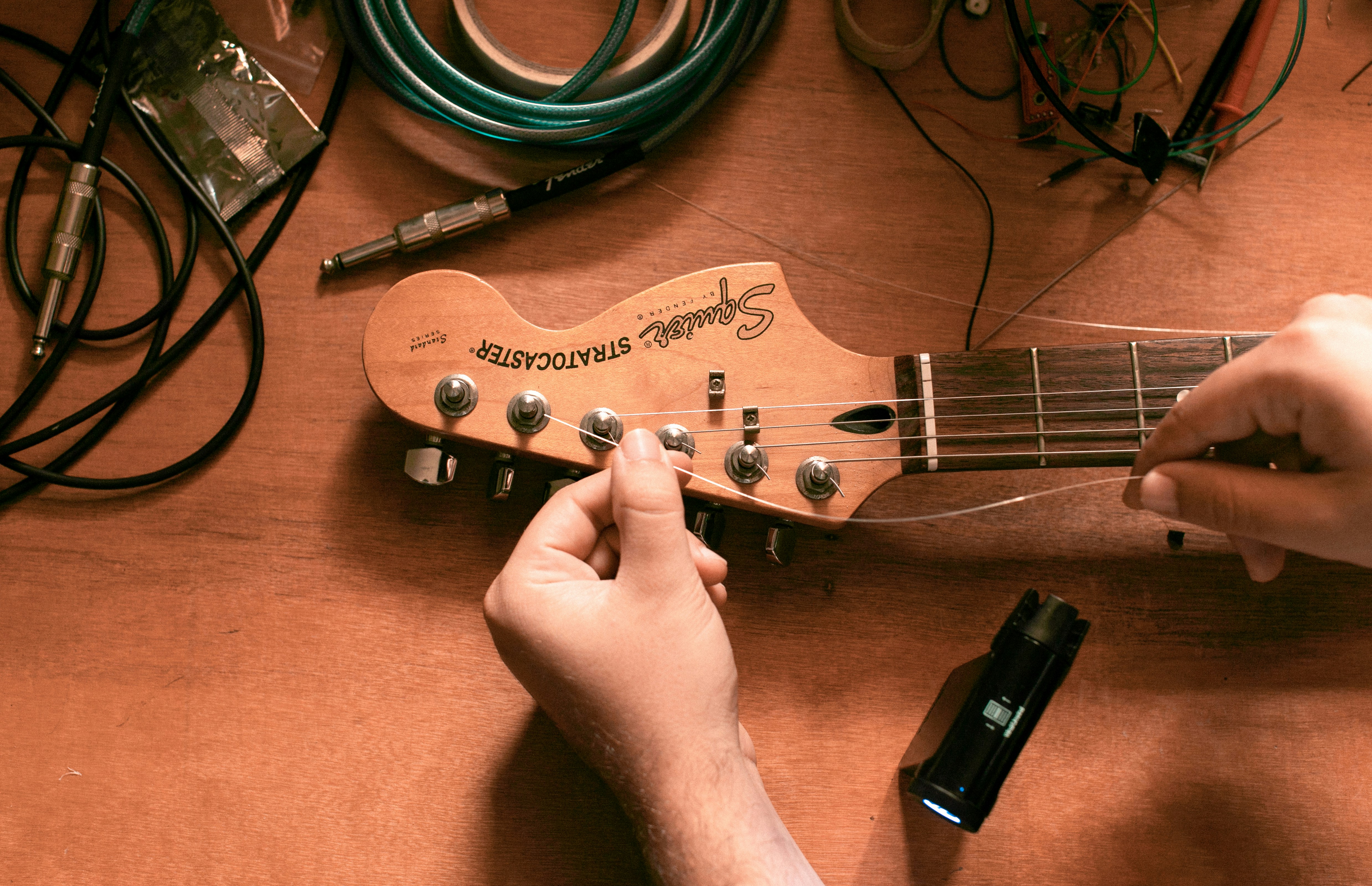 Man restringing guitar