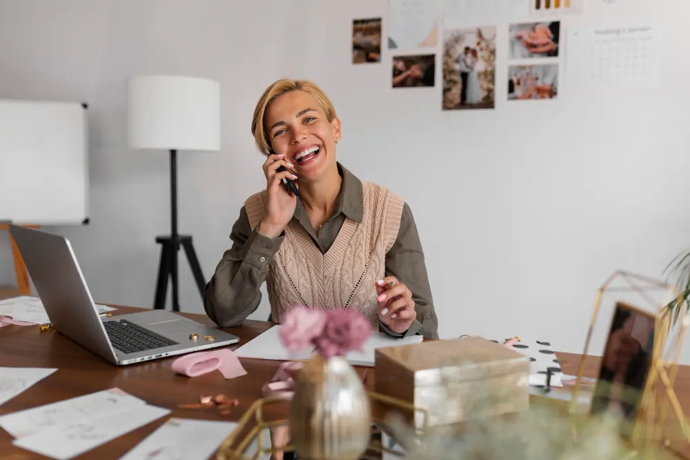 Small business owner smiling while on a phone call at her desk