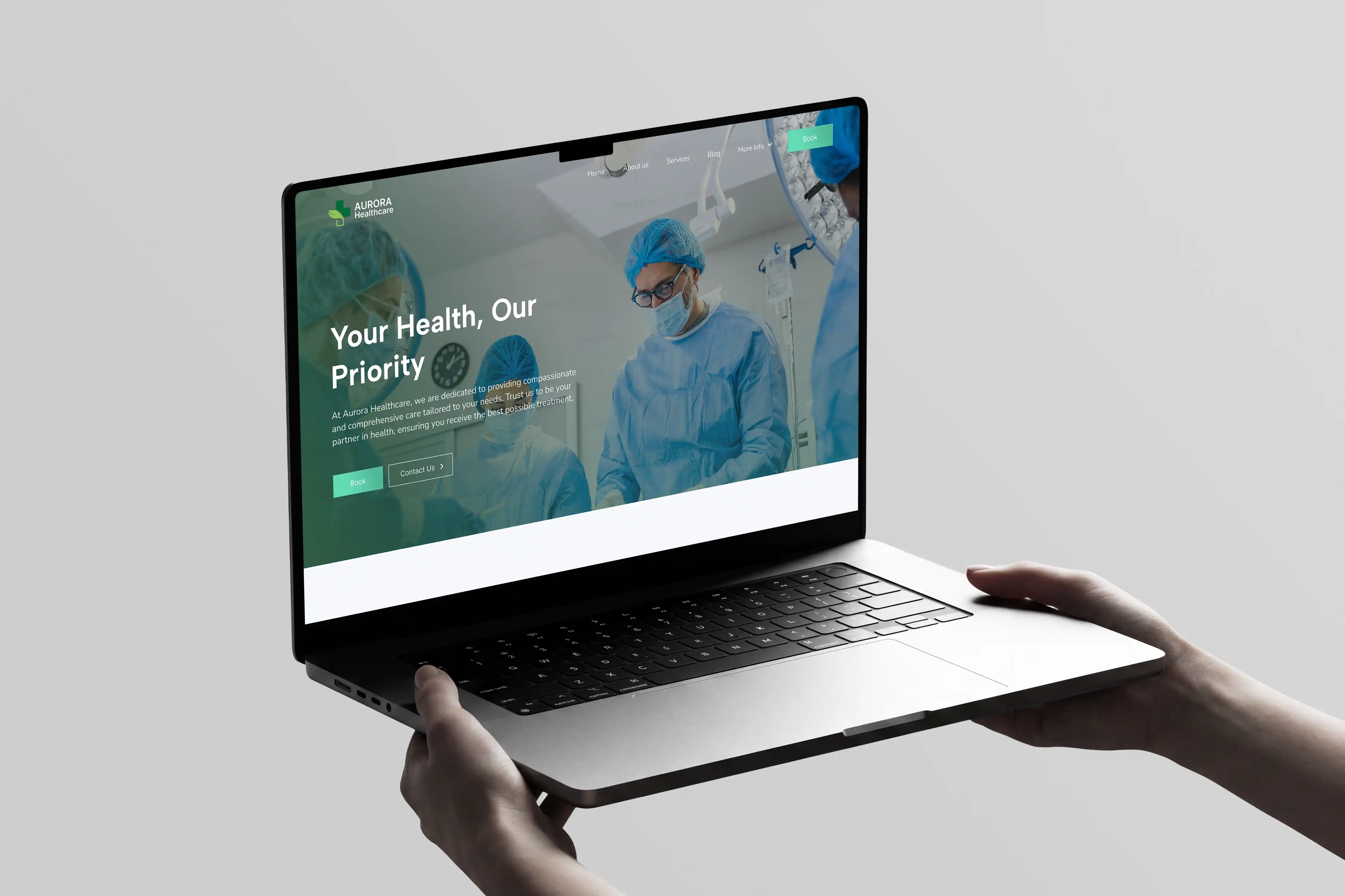 Hand holding a laptop device displaying the Autora Healthcare website