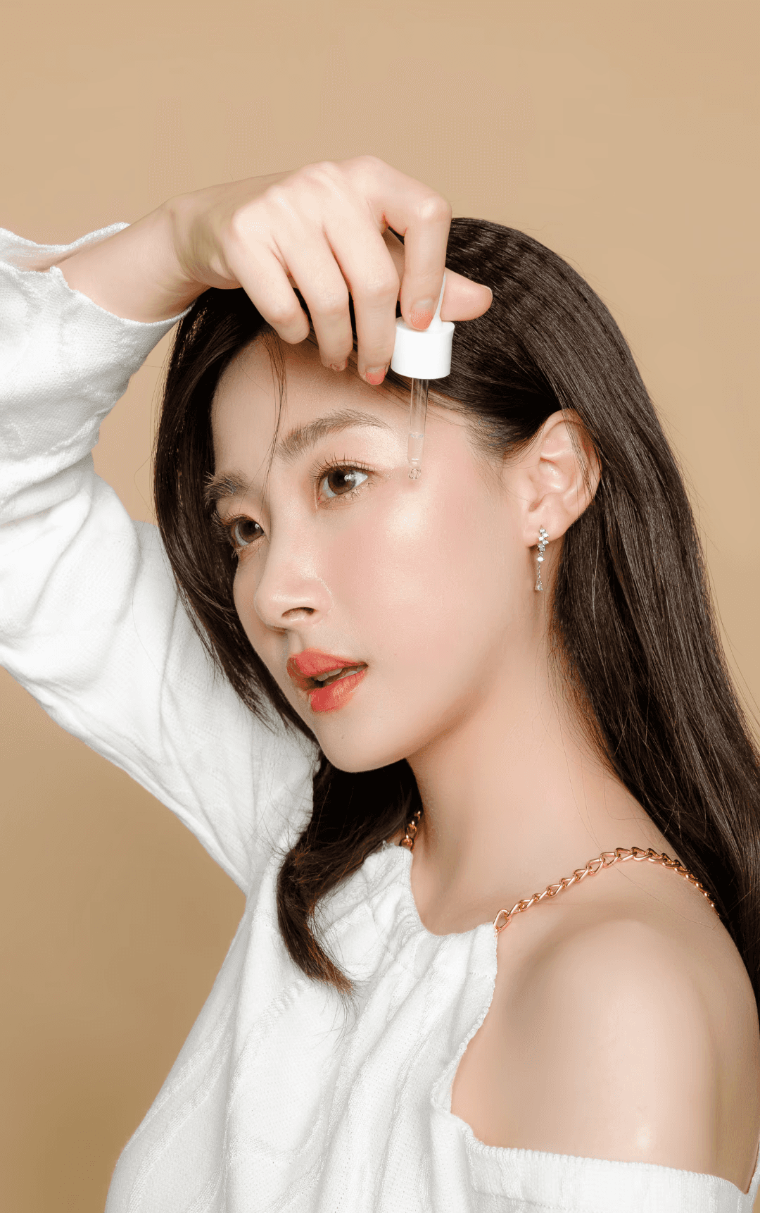 Portrait of a woman with long red hair and closed eyes, gently touching her face with both hands