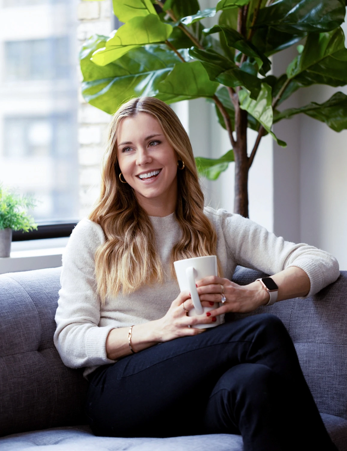 a warm and welcoming smile on the face of an expansive therapy therapist having a conversation while holding a beverage casually representing the deeper in person connection found through face-to-face in-person therapy in new york city.