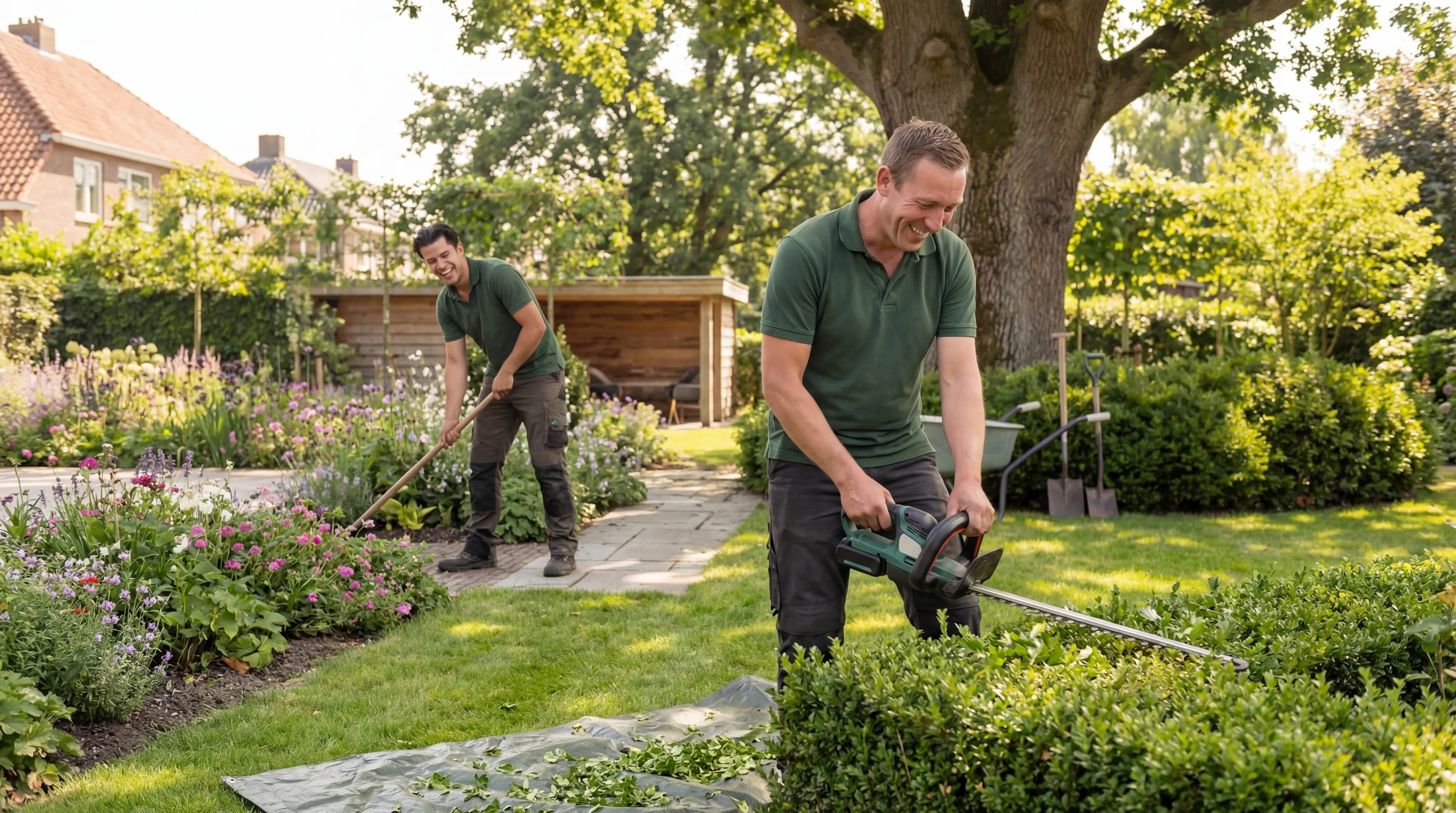 Twee tuinmannen snoeien en onderhouden een groene tuin met bloemen en struiken.