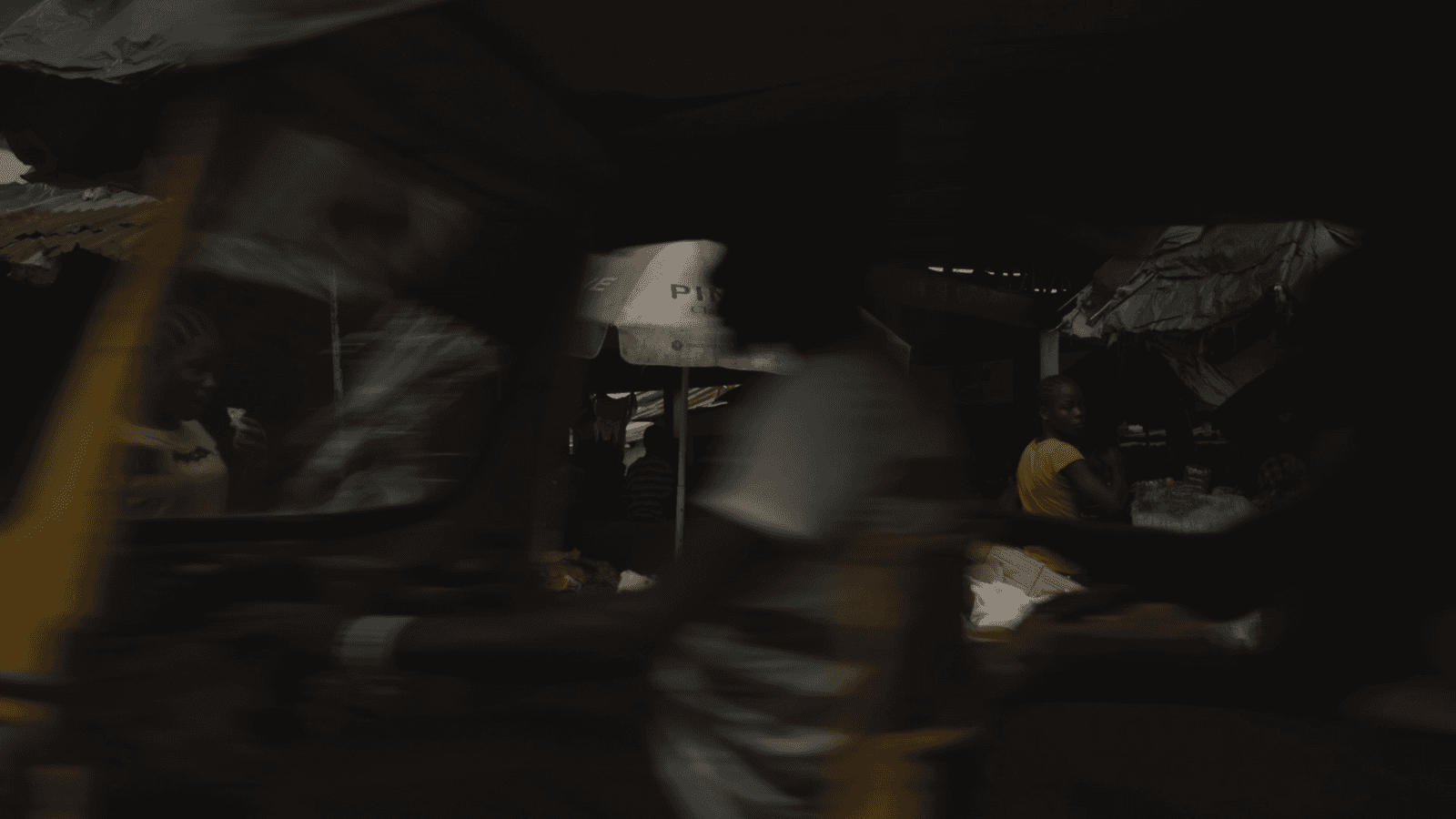 Dimly lit interior scene in Liberia, still from A Sweet Land of Liberty, a film by Andrew James Benson