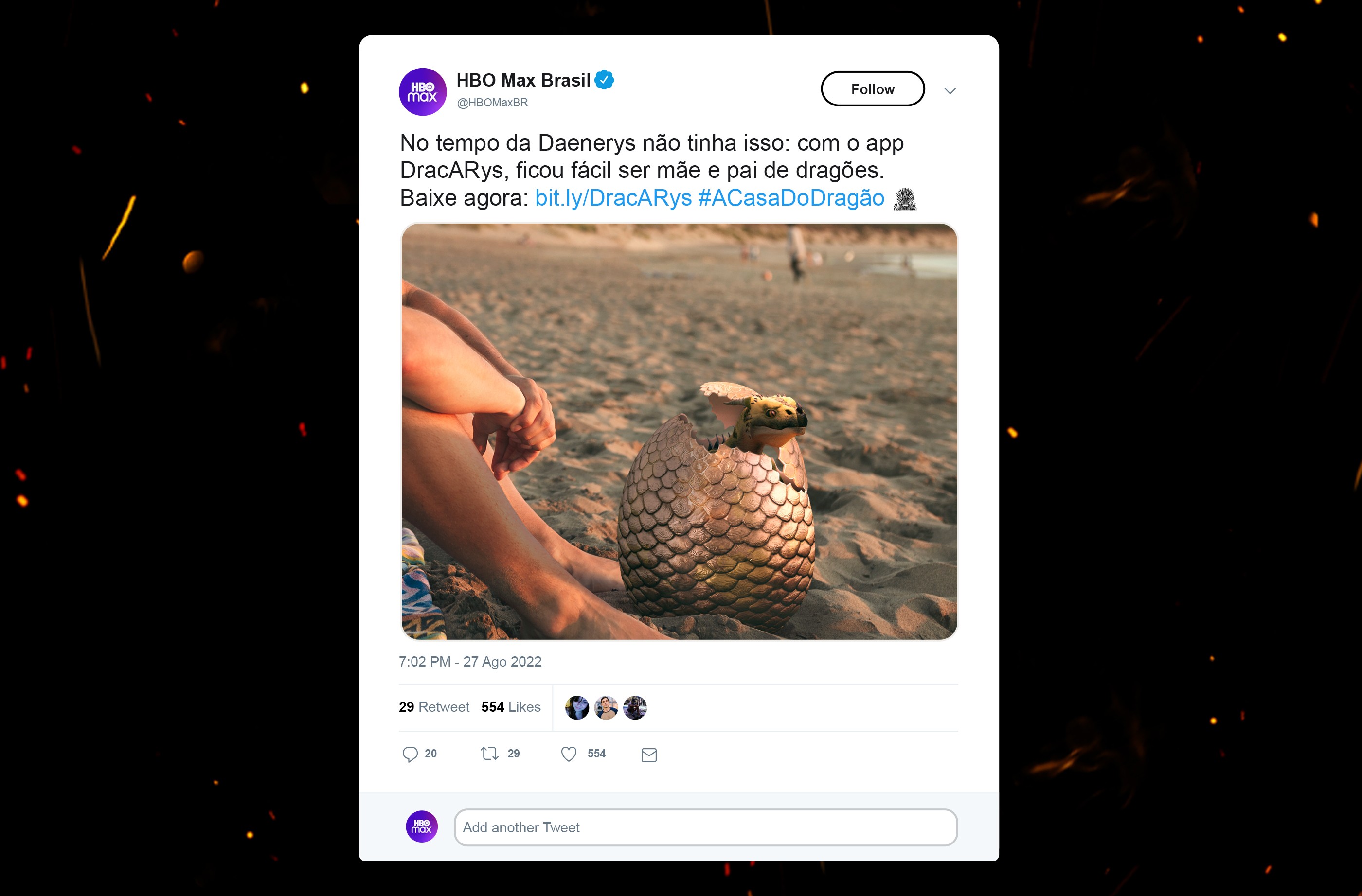 Man on a beach with a dragon’s egg hatching in the sand beside his feet in a social media promotion.