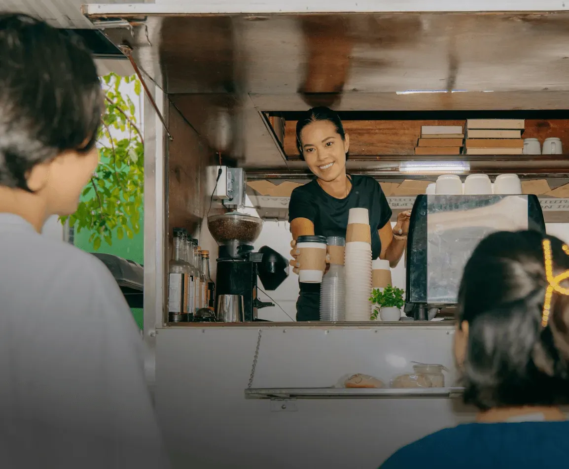 A local Tampa coffee truck serves two patrons, with an employee preparing drinks, showcasing efficient design and integration of business services.