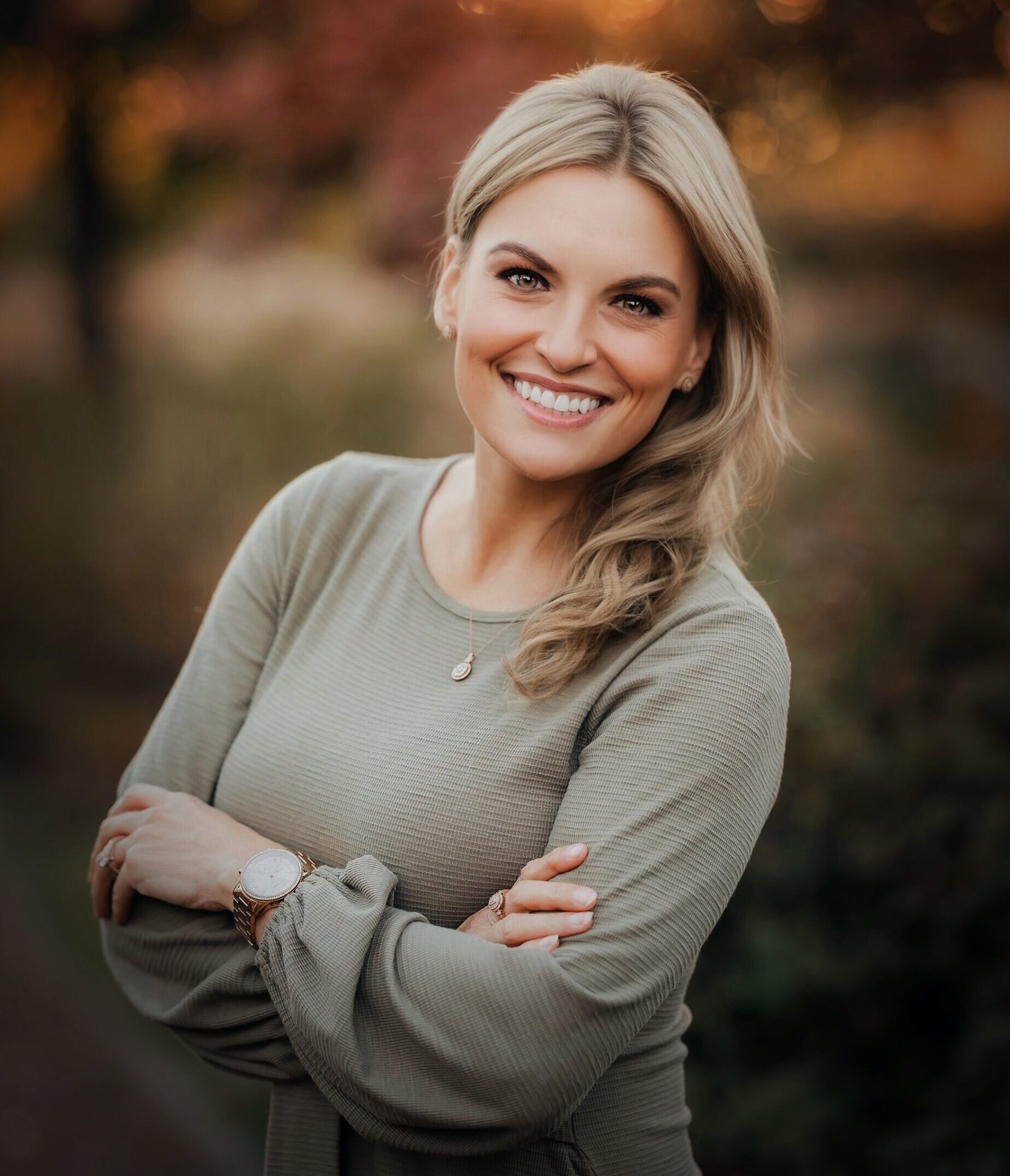 A man with glasses and a beard is looking directly at the camera, seated in a cozy, dimly lit café.