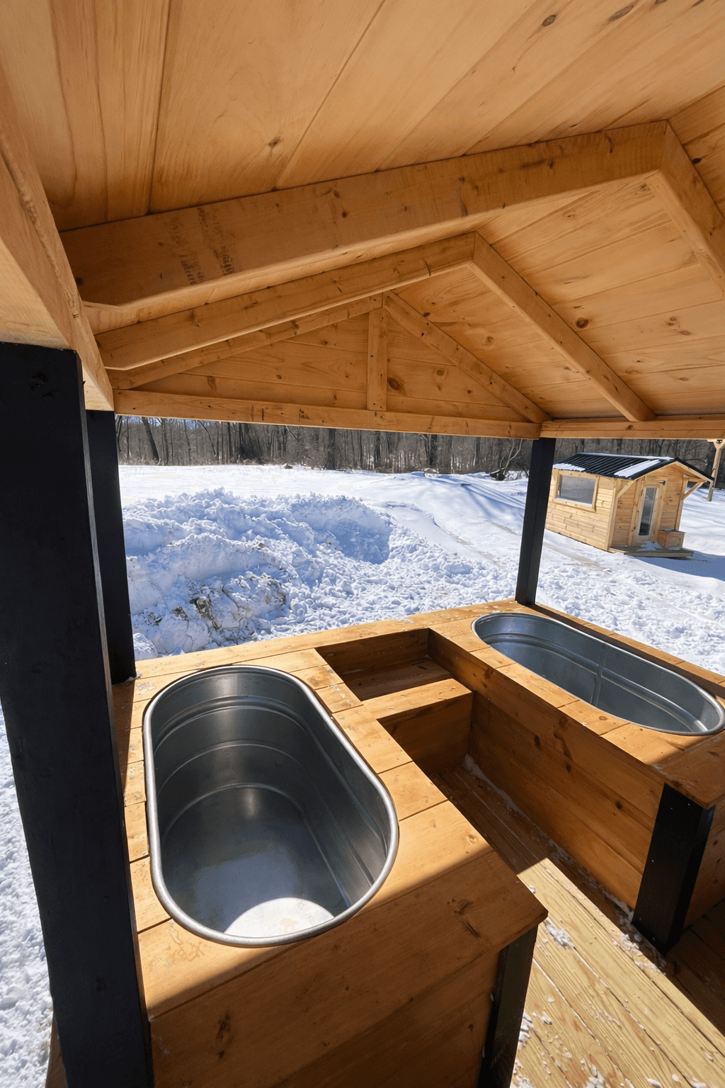 Outdoor cold plunge tubs beside a mobile sauna used for contrast therapy and recovery in Newport County, Rhode Island.