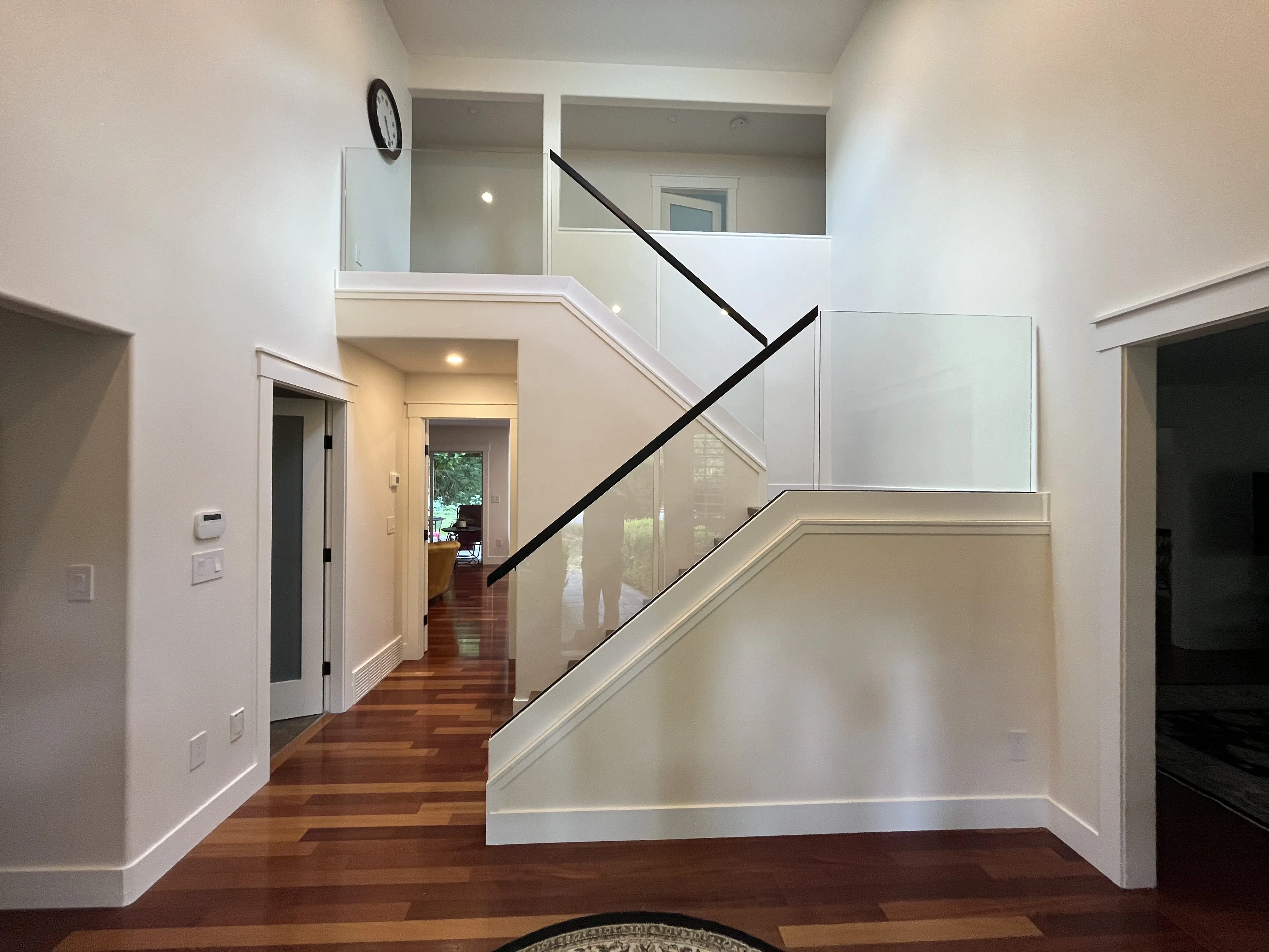 Frameless glass railing along an interior staircase and upper loft landing