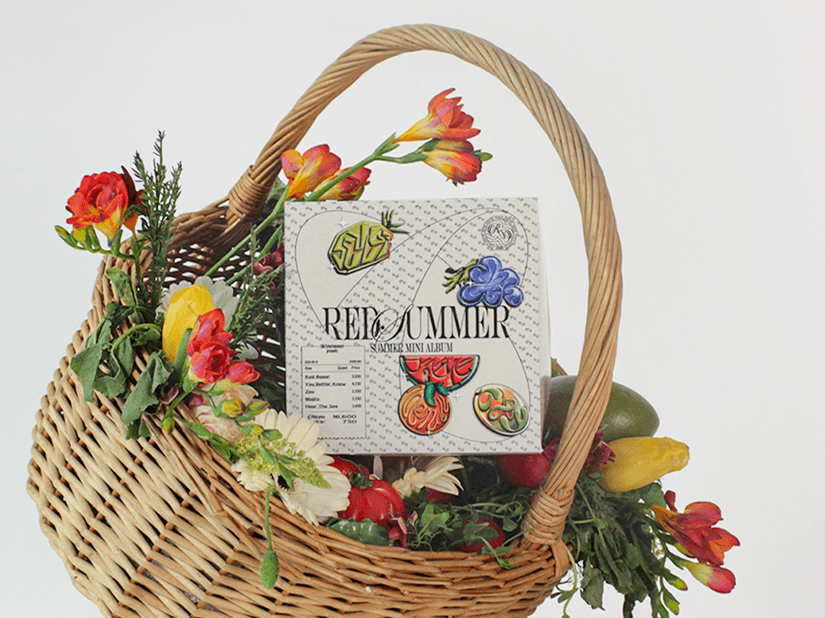 Modern red brick apartment or office building viewed from below against a blue sky, showcasing its geometric architecture with evenly spaced windows and balconies.