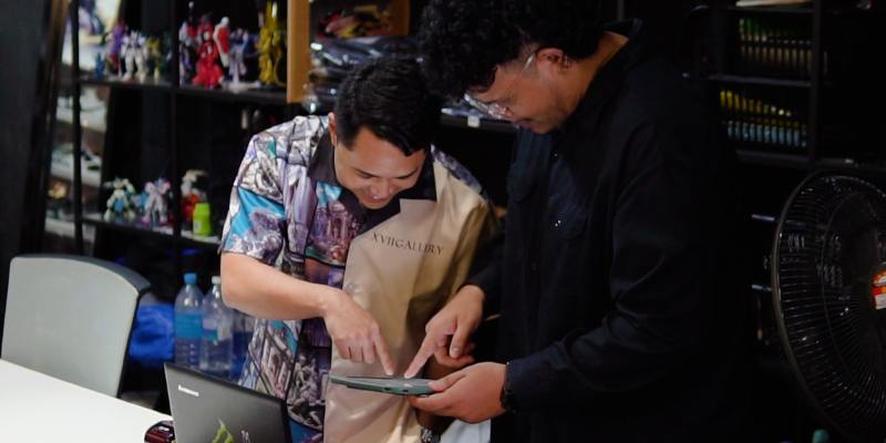 Seorang peniaga butik kasut lelaki sedang menganalisis laporan jualan menggunakan POS ipad bersama pekerjanya.