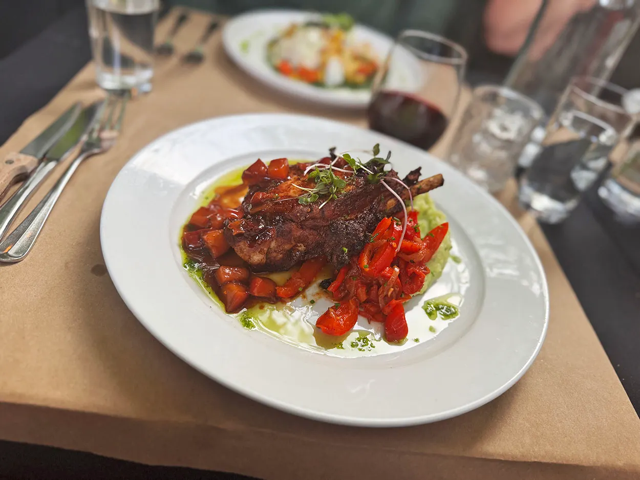 Plated main course with roasted tomatoes at Basi Italia
