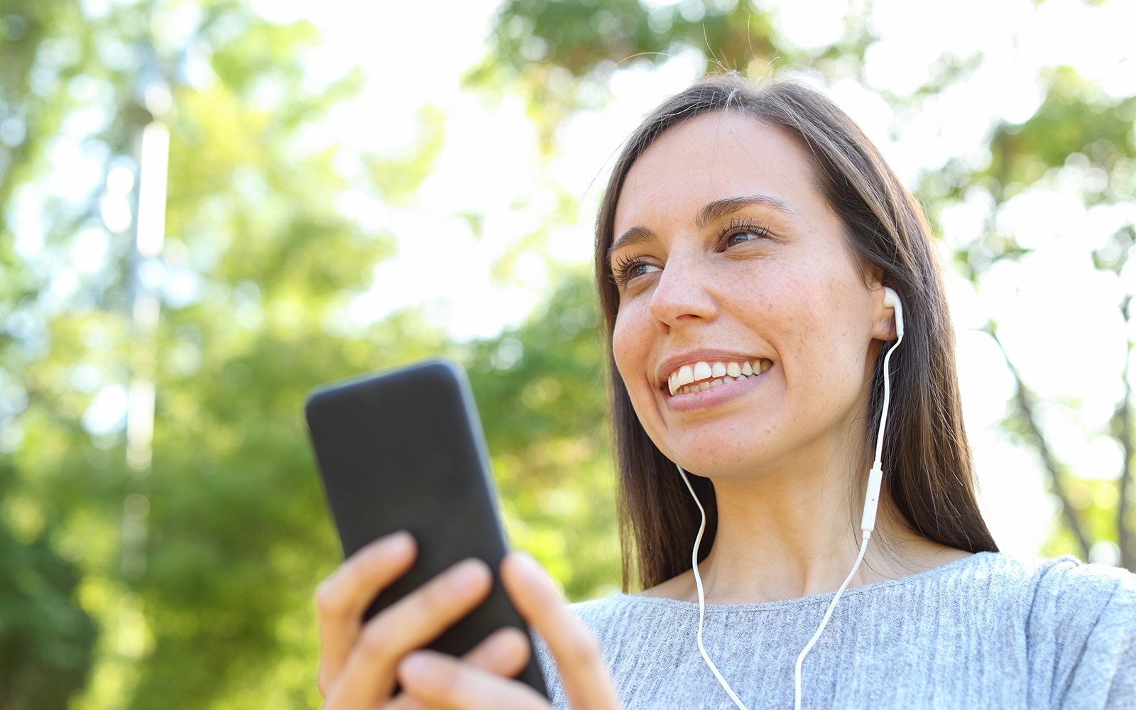 女士在尚蒂伊城堡之旅中通过手机收听语音导览。