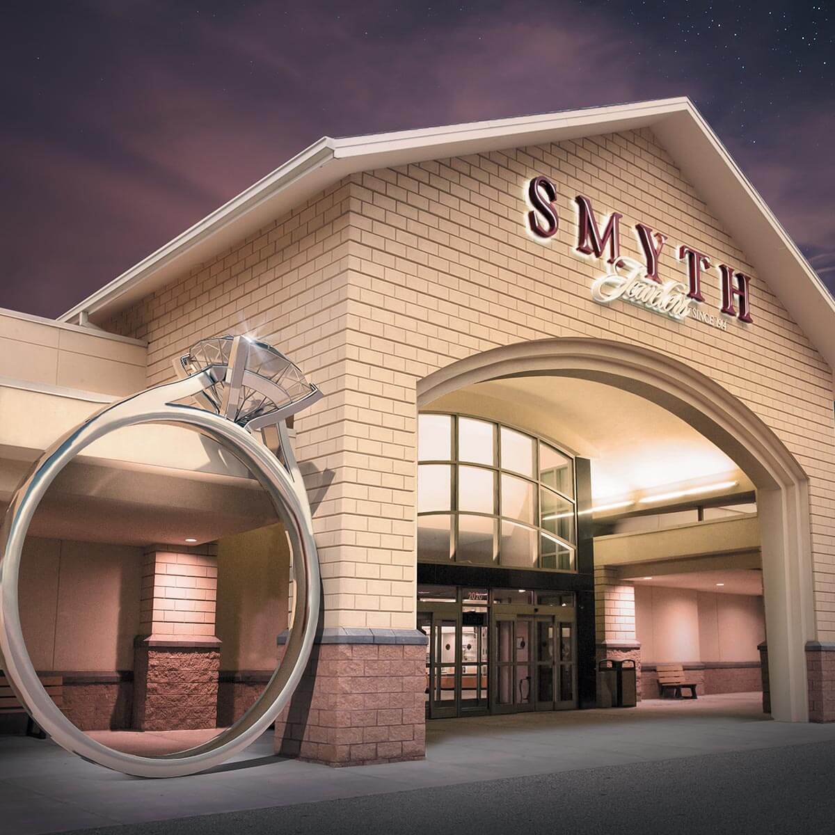 The entrance of Smyth Jewelers features a large decorative ring sculpture beside the doorway under a cloudy evening sky.