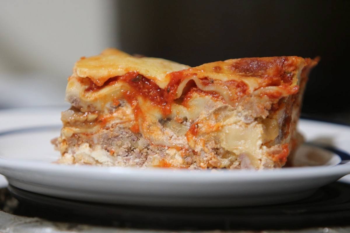 Slice of homemade lasagna with tomato sauce and cheese