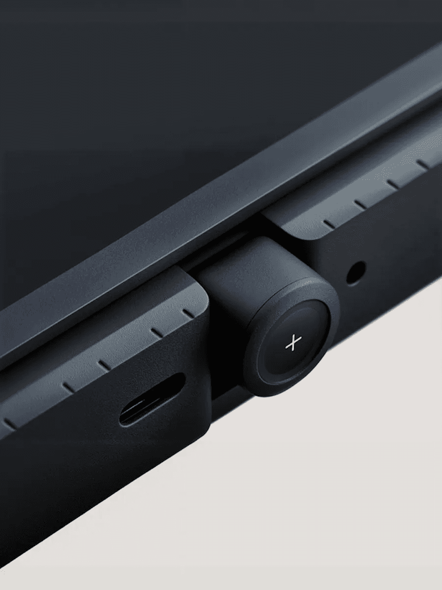 Close-up of a black device knob with a plus sign.