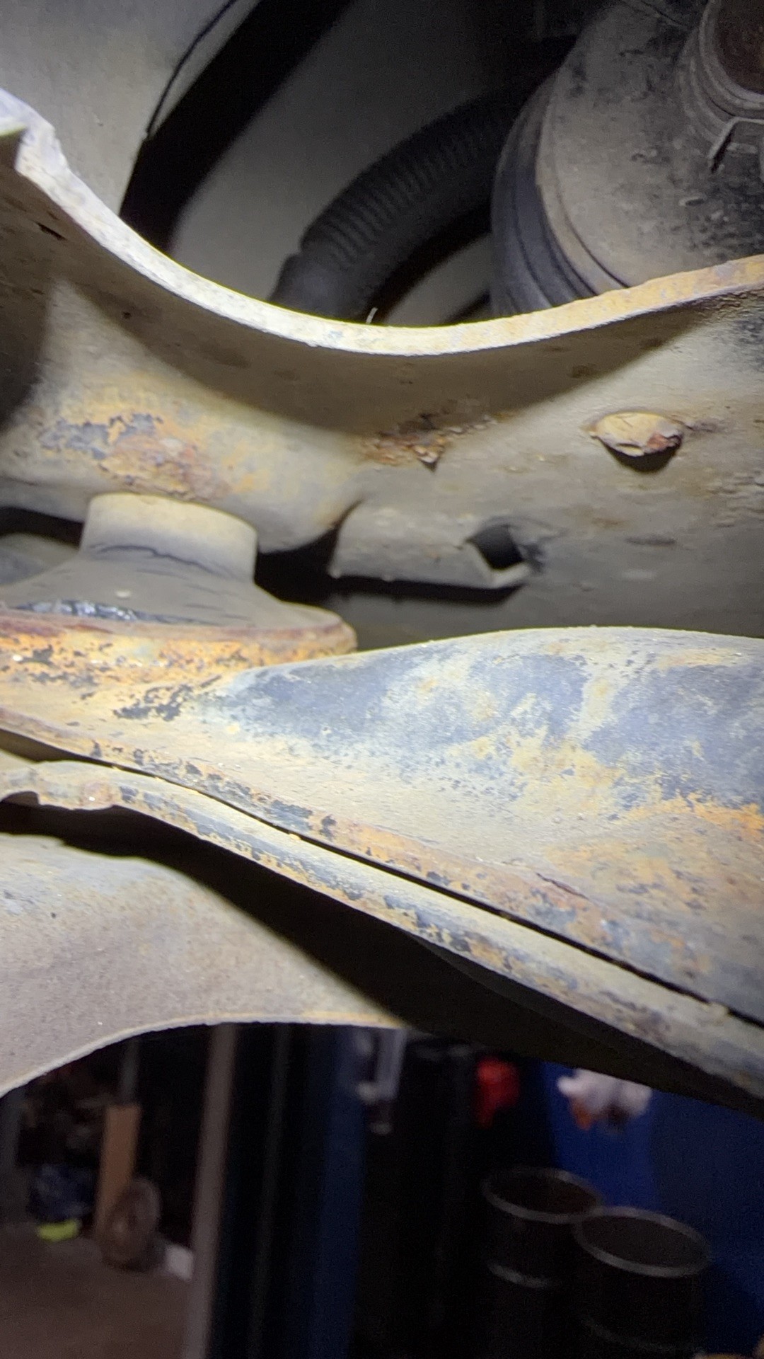 Front lower control arm on the Pontiac Sunfire with rust and the bushing area starting to separate