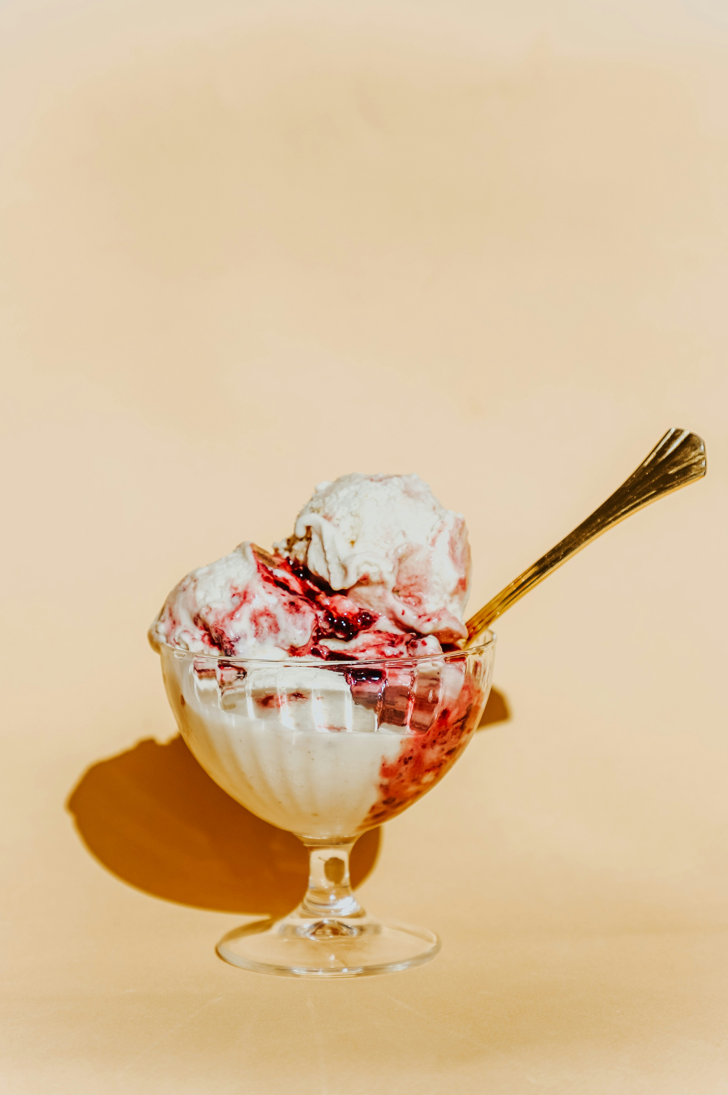 Creamy ice cream scoops in glass with spoon