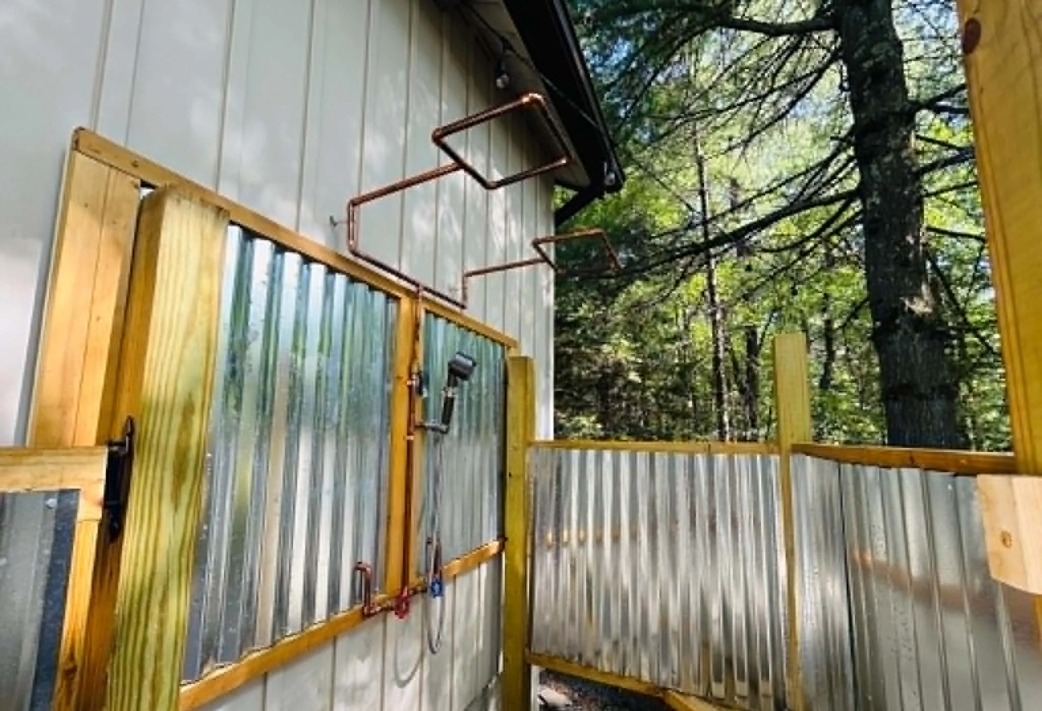 Outdoor shower with two heads and corrugated metal walls at Get Lucky On Lupine, Lake Harmony, PA