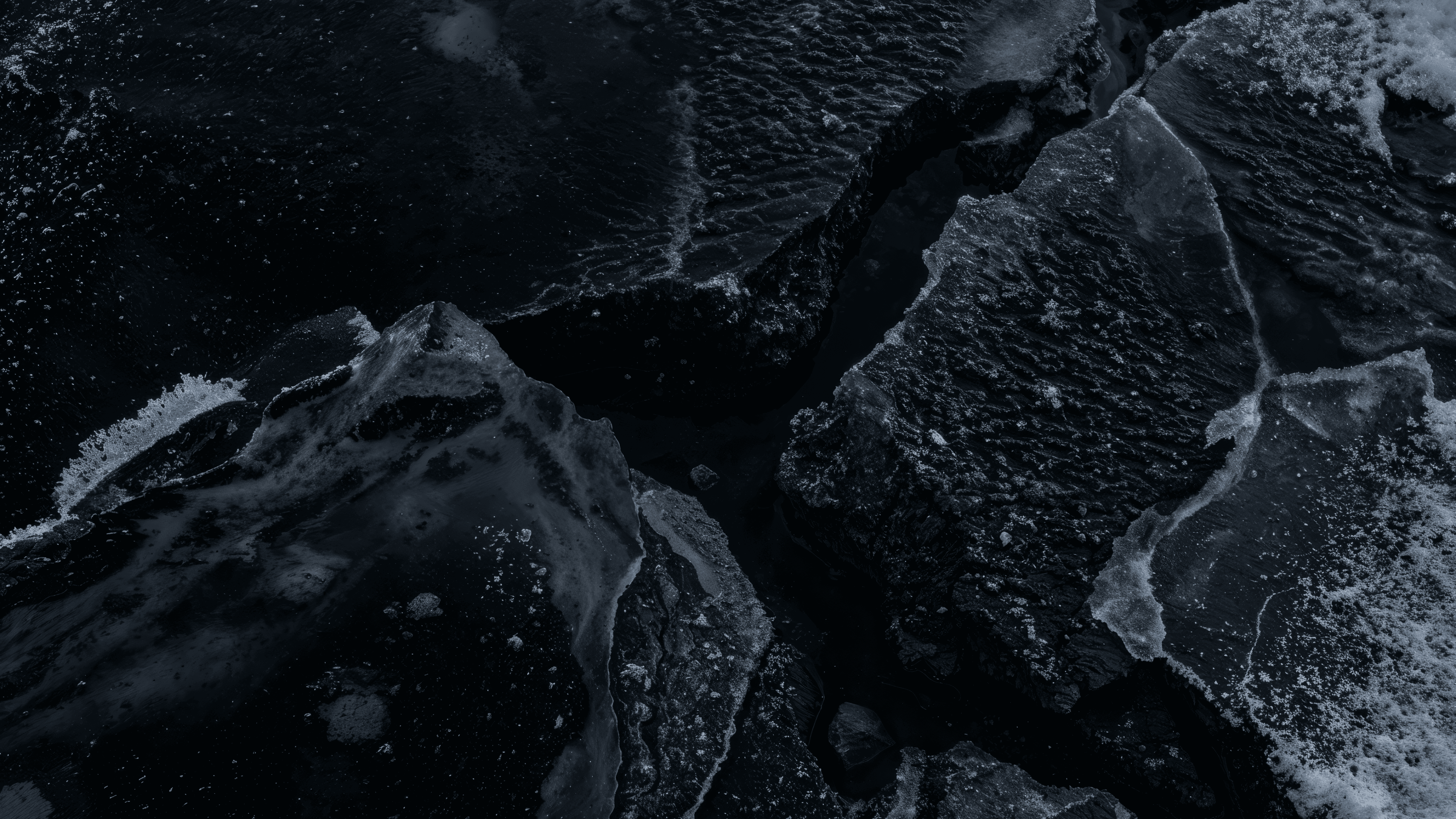 A macro study of obsidian-toned ice shards and crystalline fractures, capturing the high-contrast, structural grit of the Berlin deep freeze