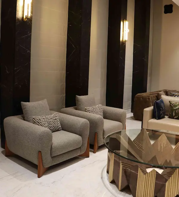 Luxury furniture featuring a two‑seater tan upholstered sofa with clean lines and slim legs