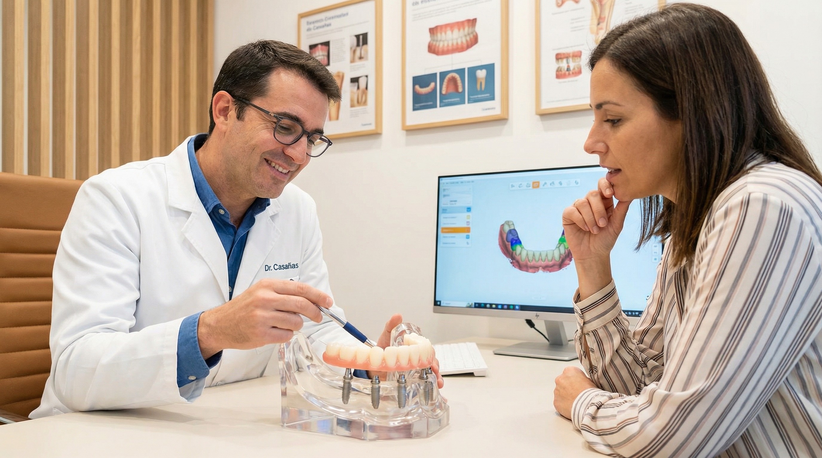 Dr. Casañas consulting with patient about all-on-4 implant treatment plan using detailed dental model