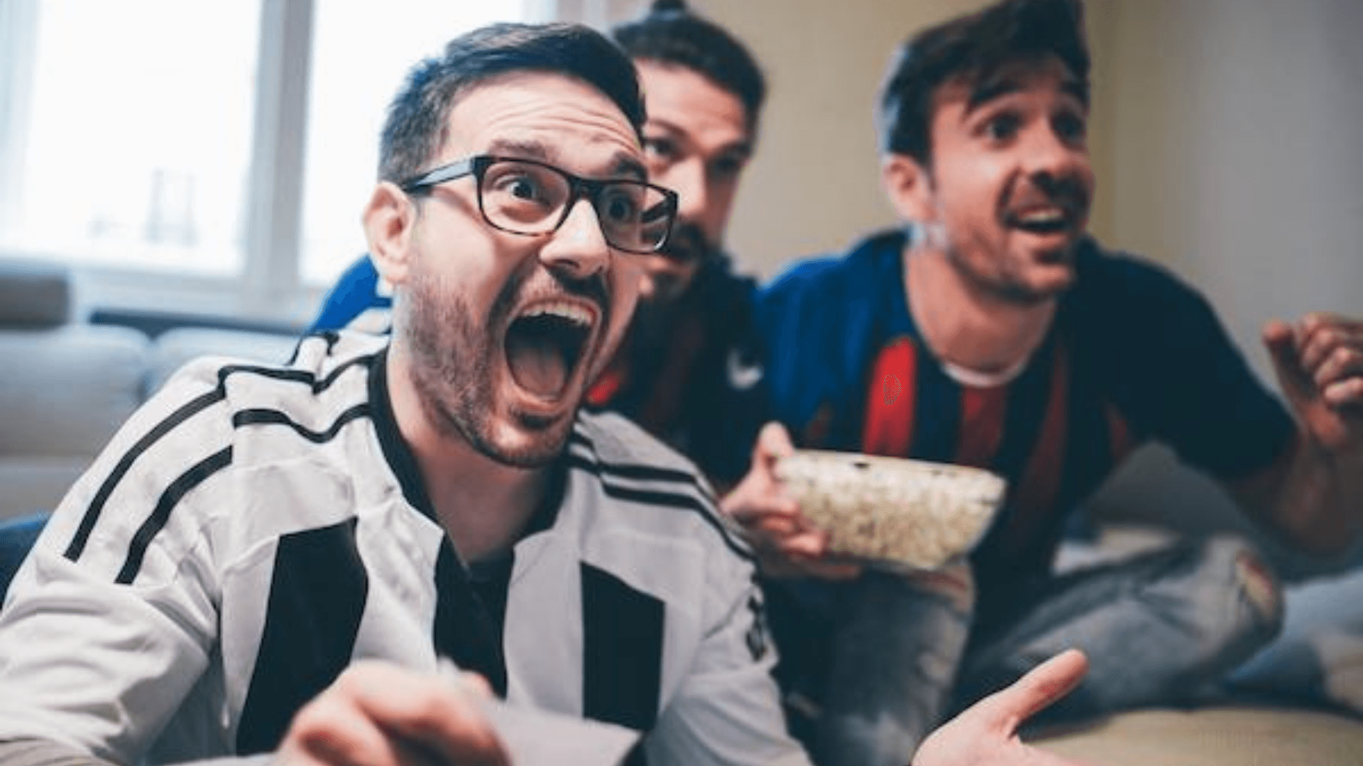 Three men watching a sports match