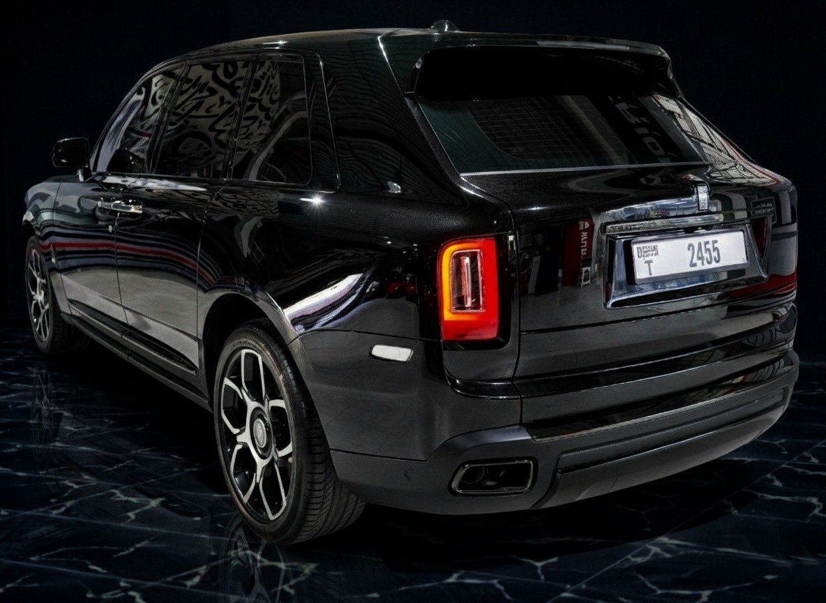 Rear corner exterior of Rolls-Royce Cullinan Black Badge 2023 in black, luxury SUV with wide stance and premium finish
