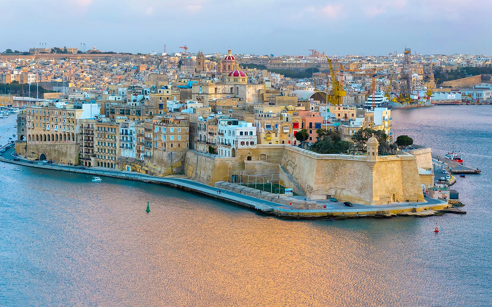 Valletta skyline and harbor view from Sliema, featuring historic buildings and waterfront.