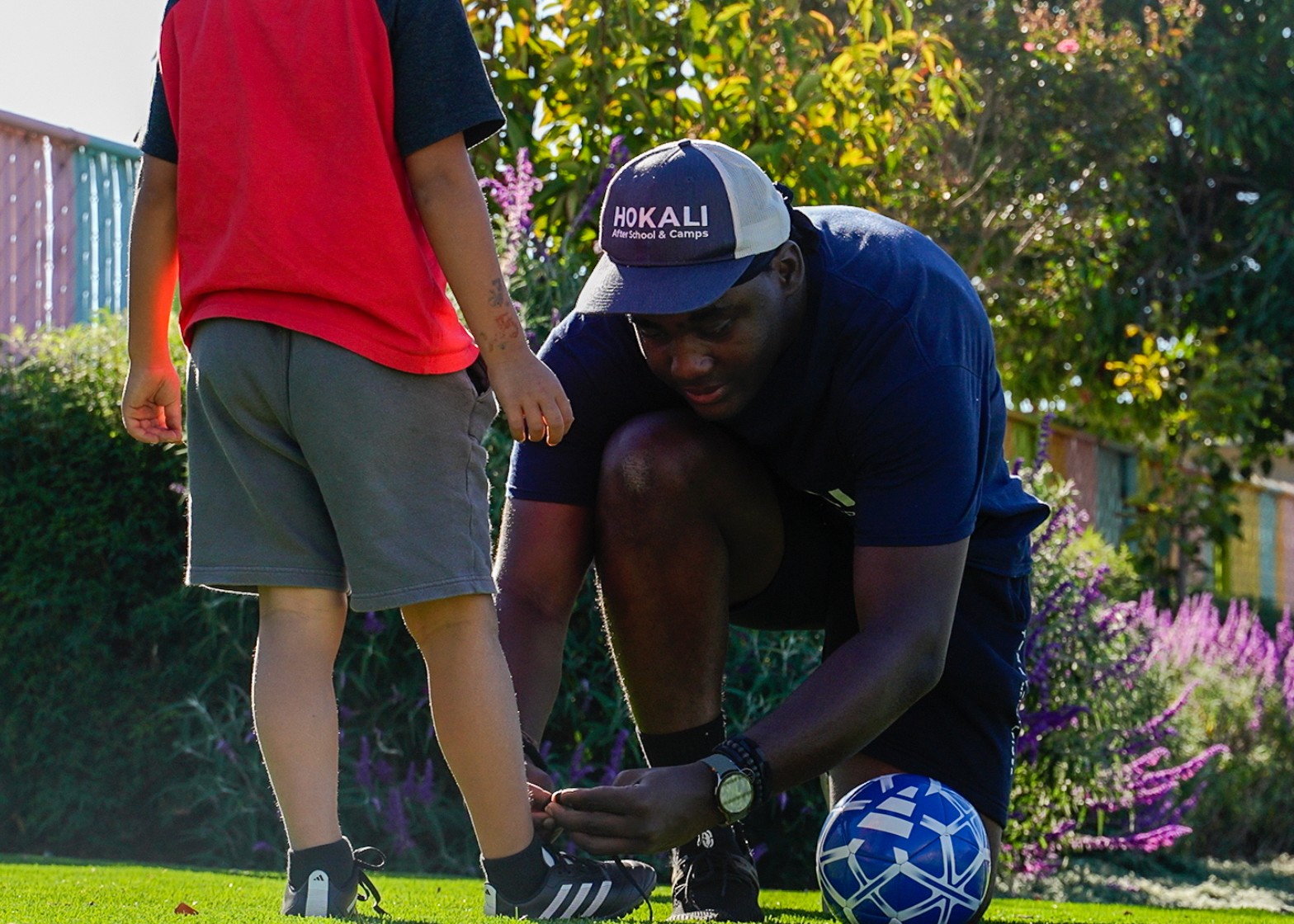 HOKALI educator helping a child during aftercare, highlighting attentive supervision and student-centered support.