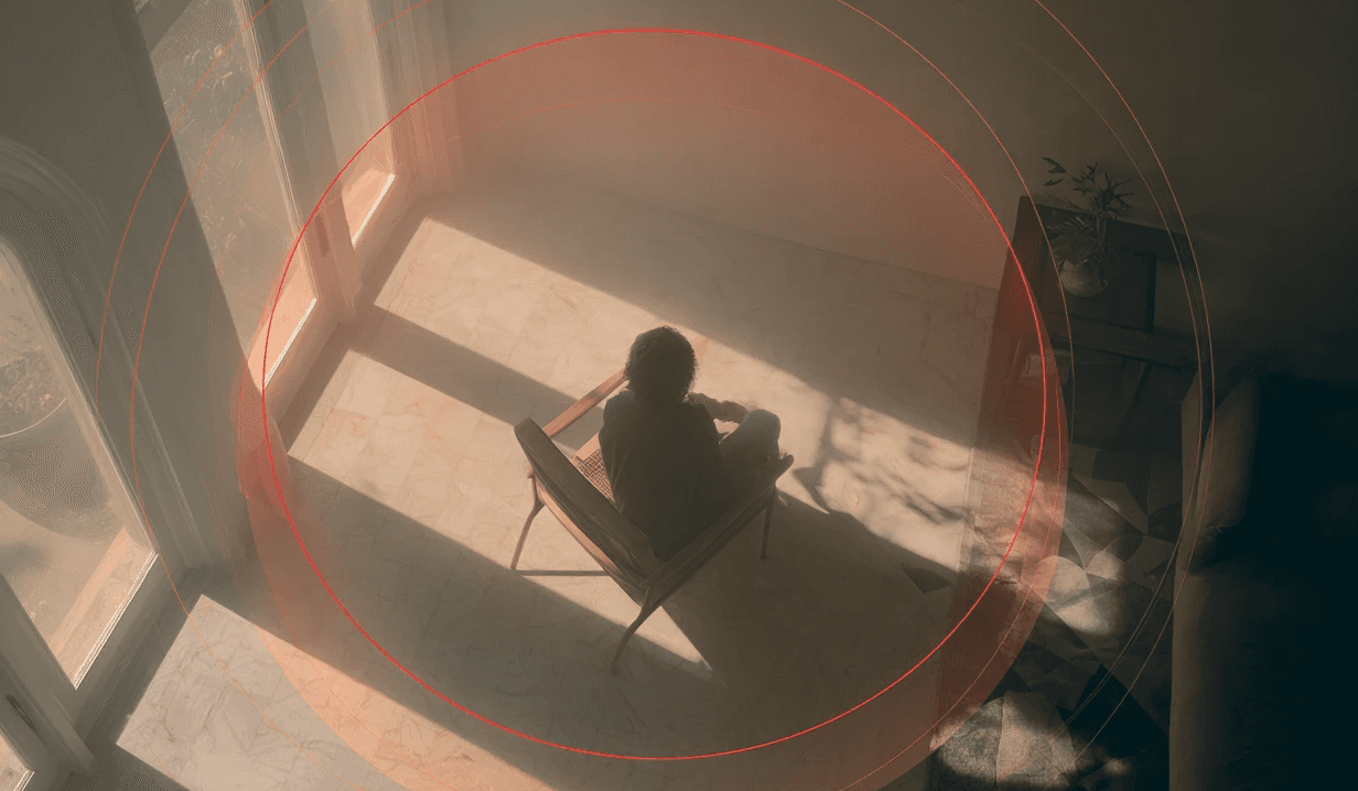 Man at desk with headphones, hunched over.