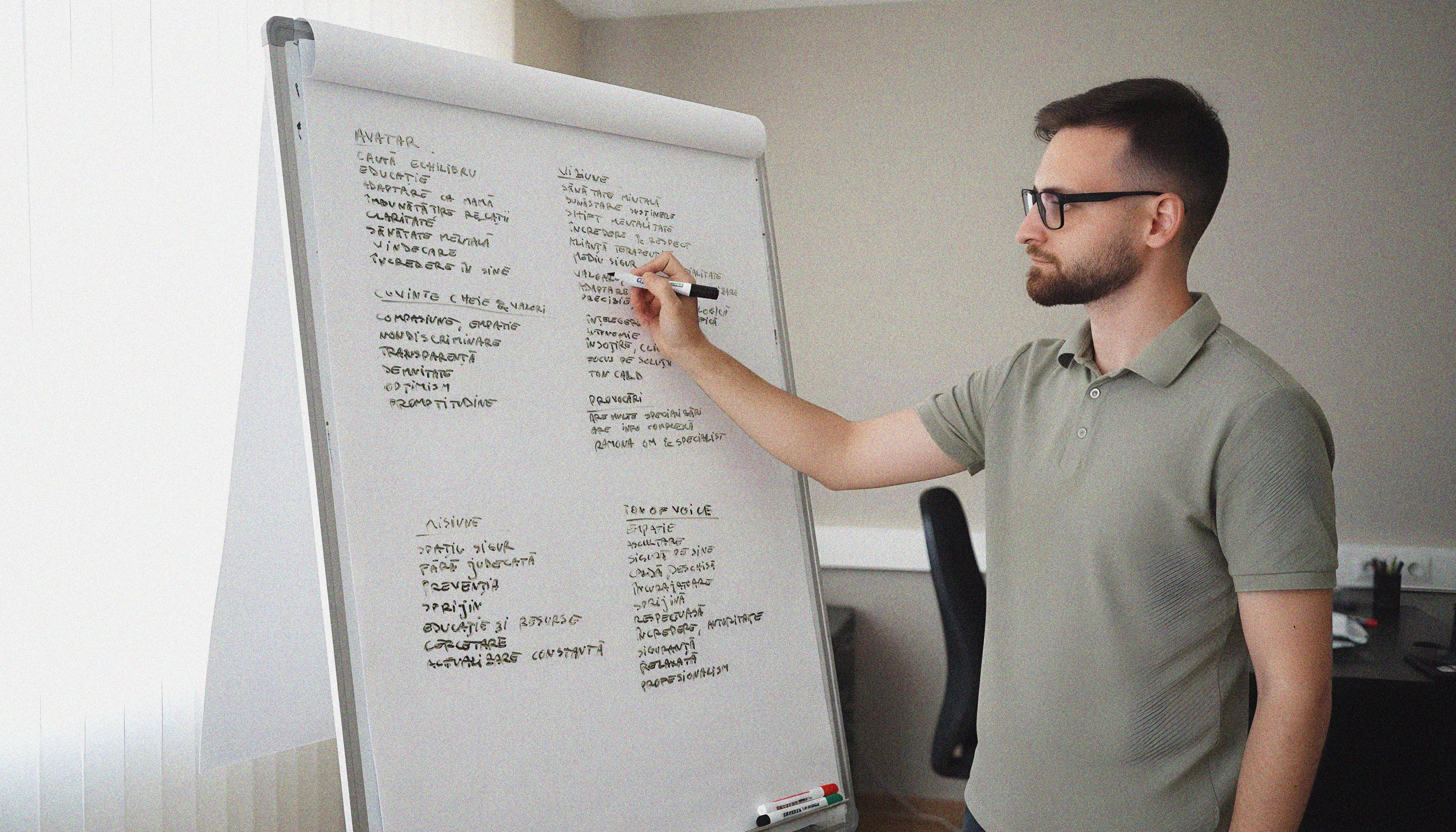 Pixel Vali la birou, analizând un proiect și scriind idei pe un whiteboard în etapa de research.
