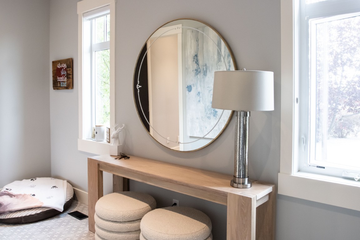 Image of KHD Homes interior design featuring a console table with stools, mirror, and lamp in a cozy room.