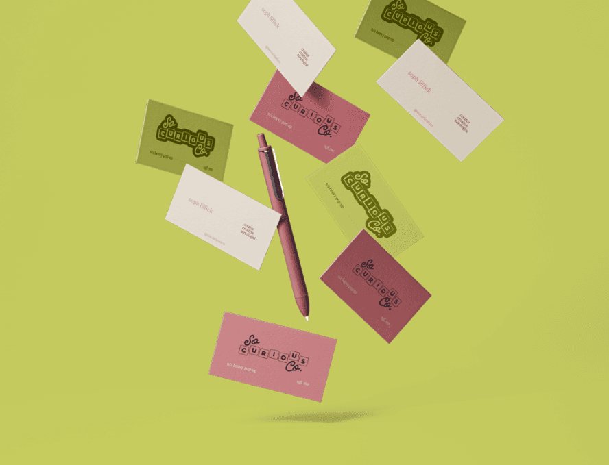 Business cards for So Curious Co falling on a lime background