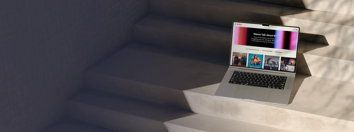 Homepage design for Netflix's global WannaTalkAboutIt.com, shown on a laptop outdoors.