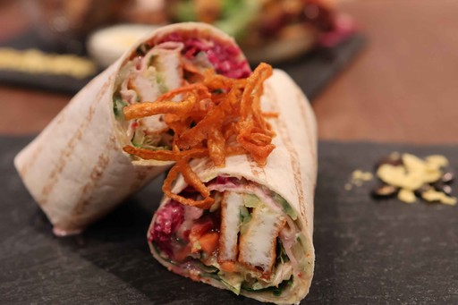 Gegrillter Wrap im kAlps mit Hähnchen, frischem Gemüse, Sauce und knusprigen Röstzwiebeln.