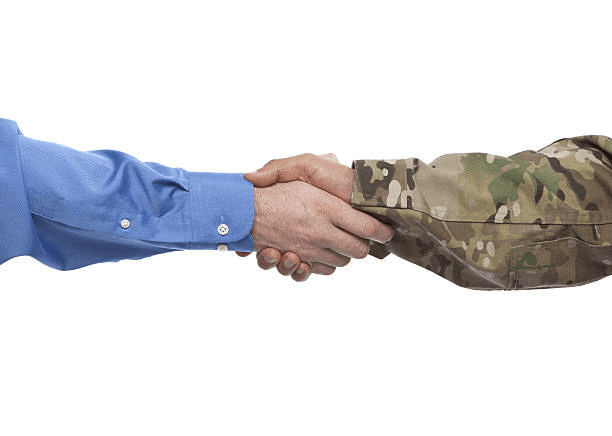 Close-up of a service member in uniform shaking hands with a business professional