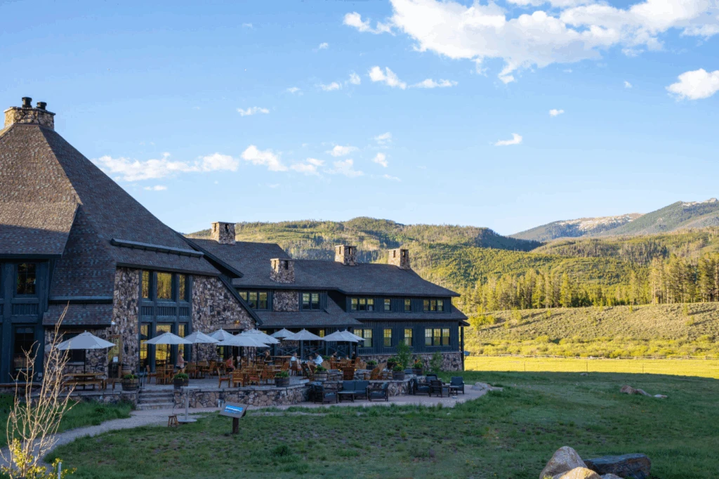 Exterior view of Devil’s Thumb Ranch in Tabernash Colorado with mountain scenery and outdoor patio seating, a popular Colorado wedding venue surrounded by open fields and alpine views.