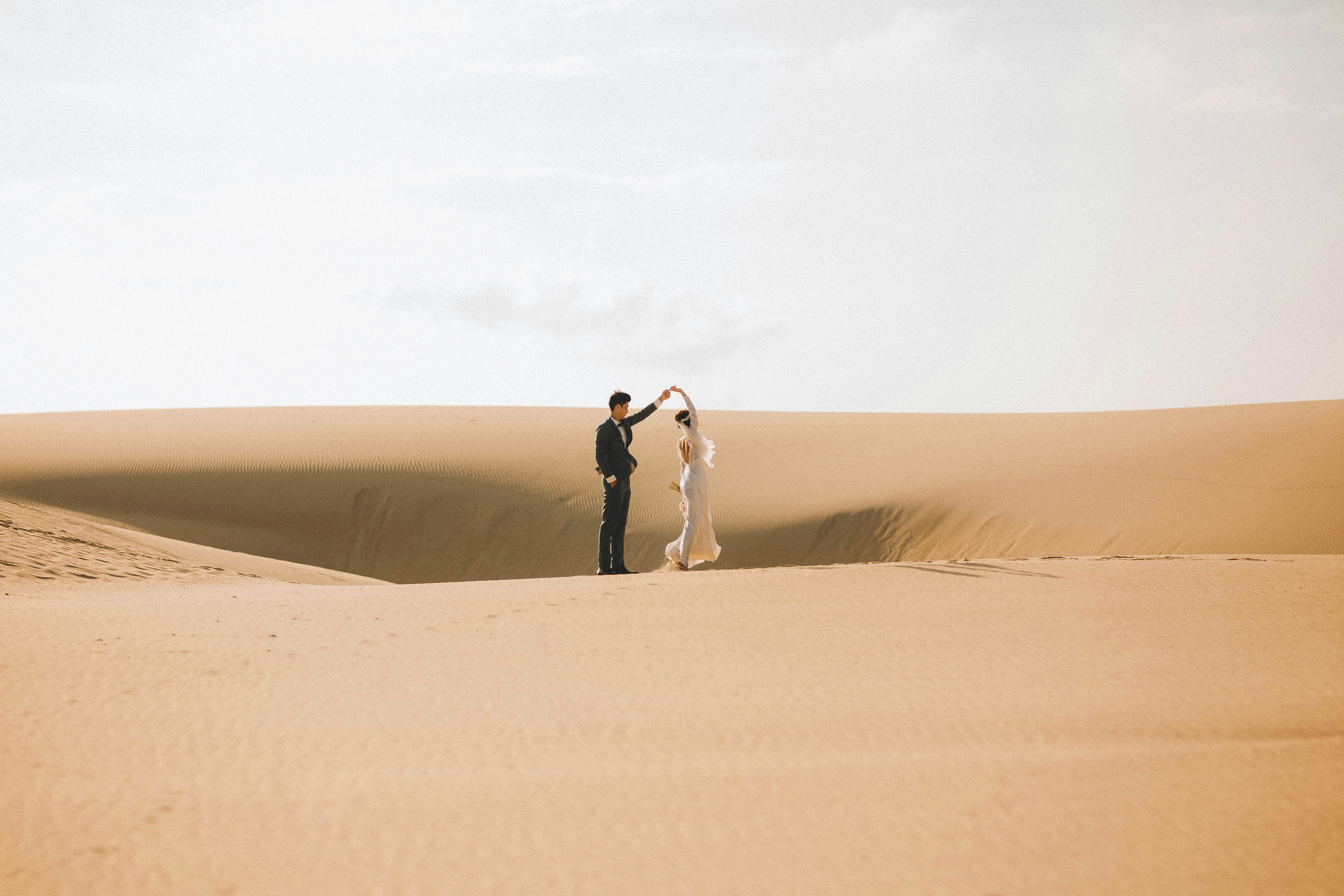 Couple dancing in a vast desert landscape