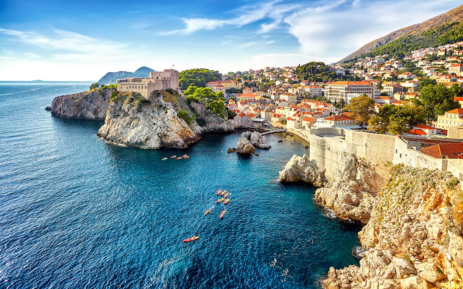 Kayakers near Dubrovnik's historic city walls and rocky coastline.