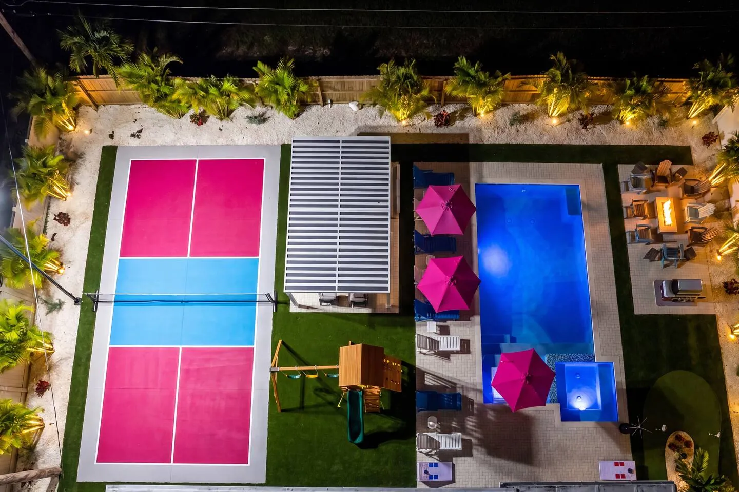 Night aerial top-down with court and lit pool at Salty House, Bradenton, Florida