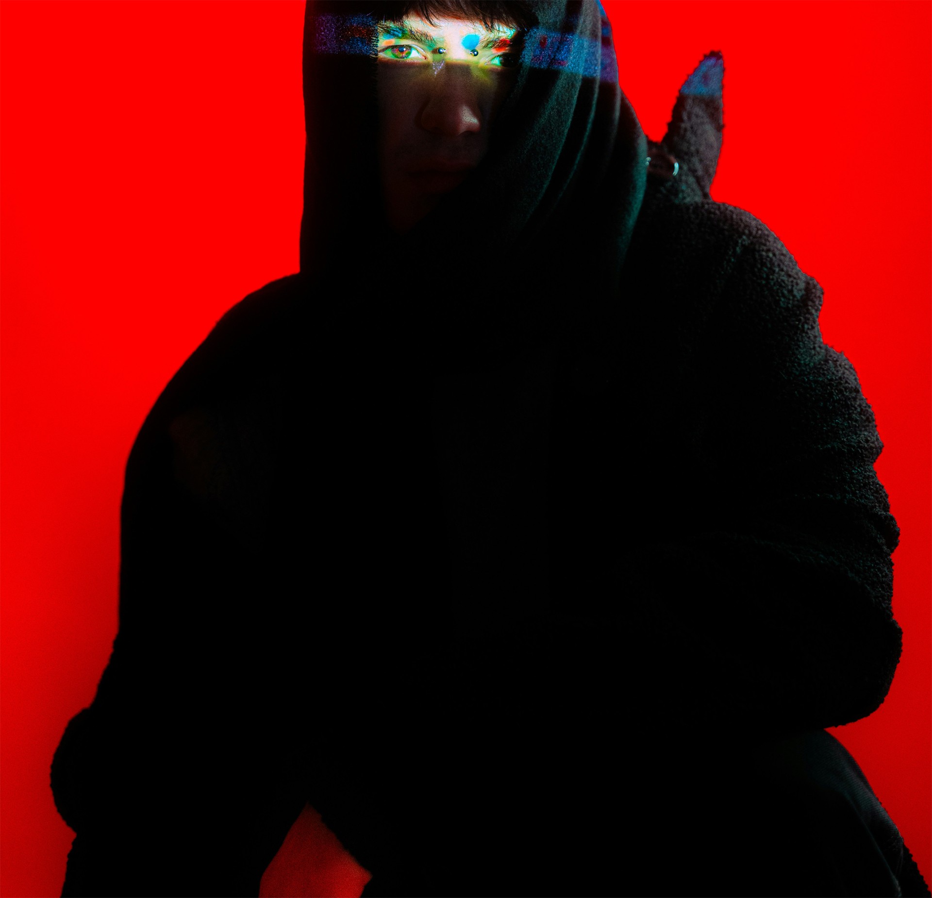 Portrait of a hooded figure against a red background