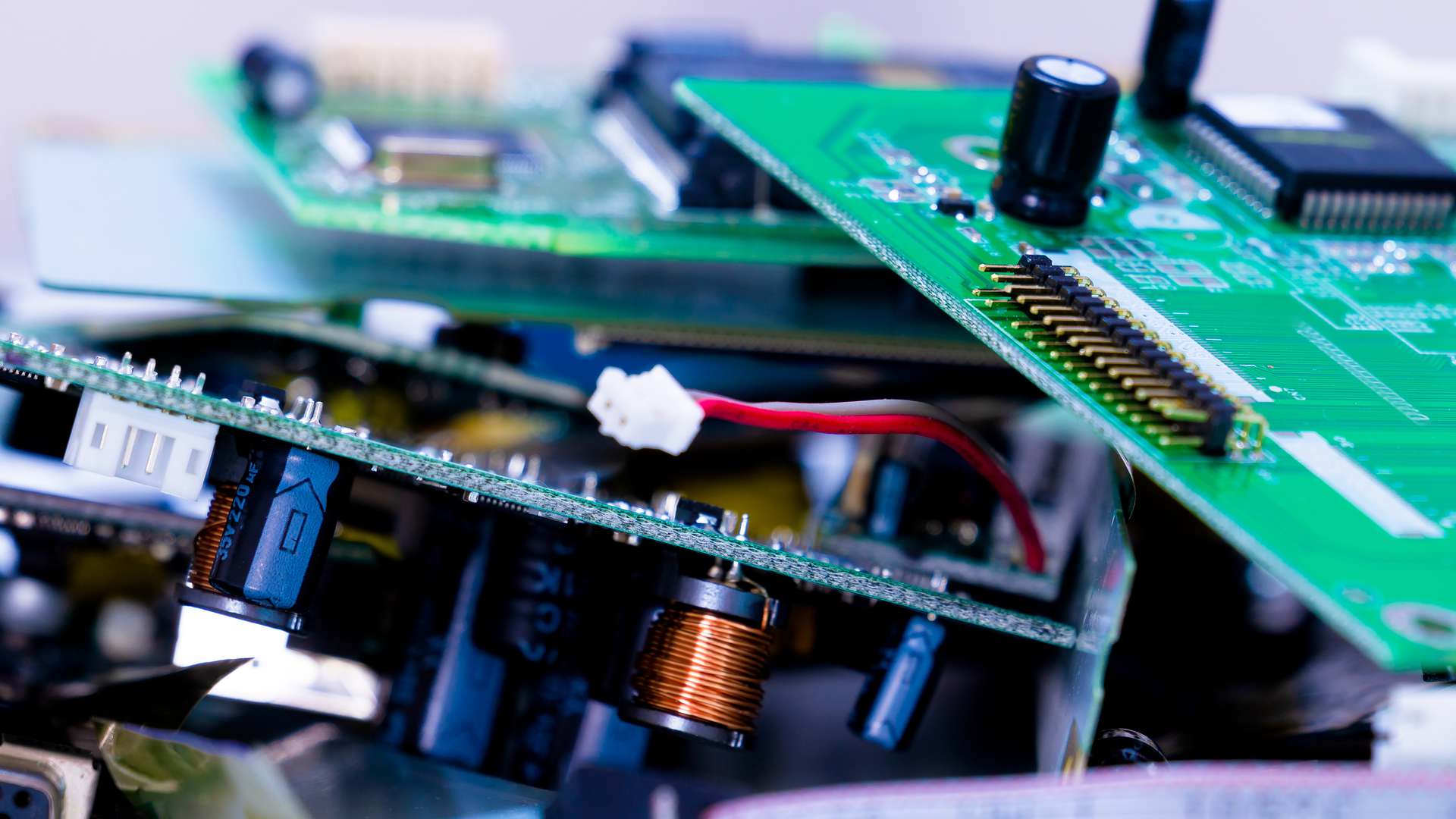 Close-up of stacked green printed circuit boards with capacitors and copper coils