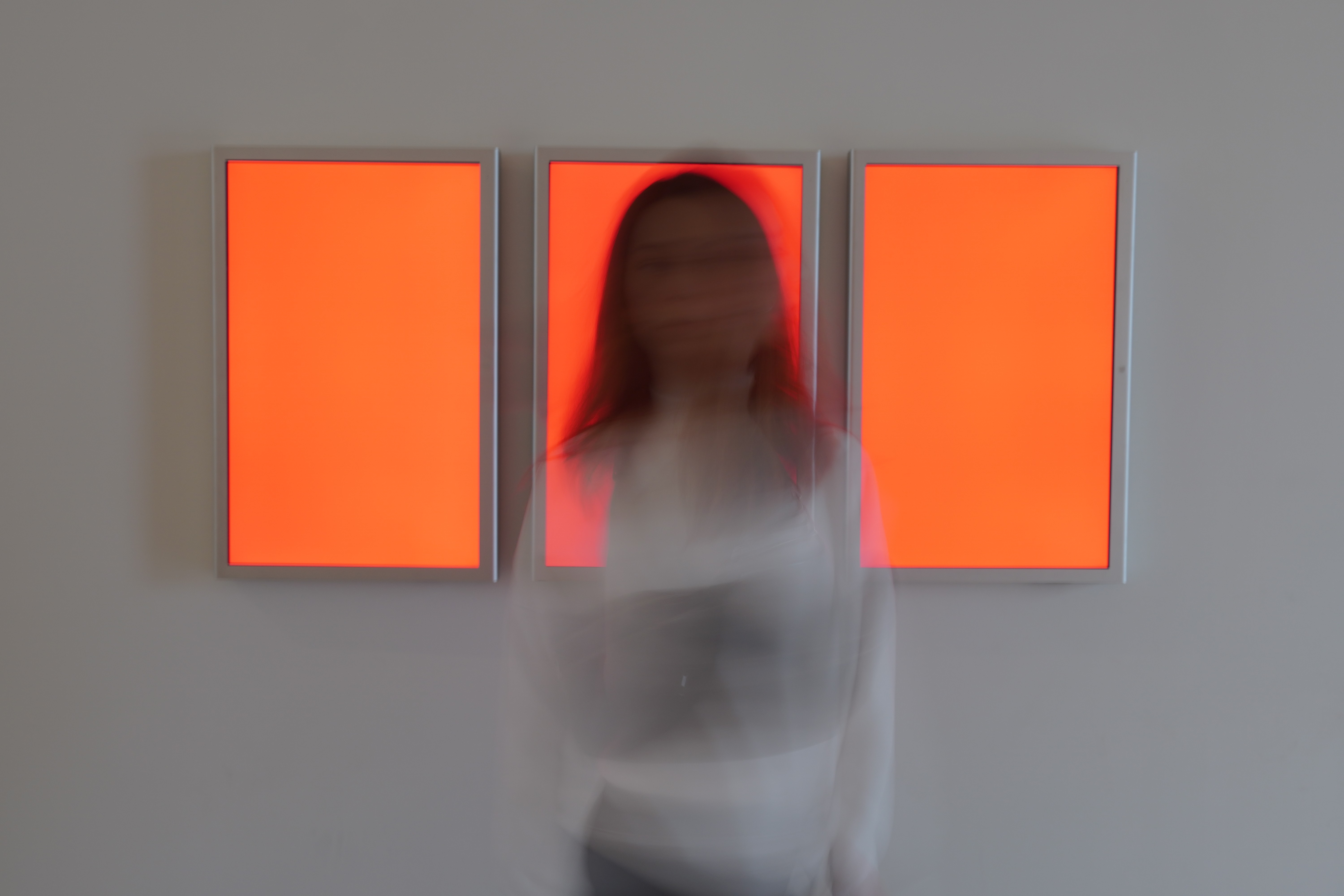 a blurry photo of a person standing in front of a wall