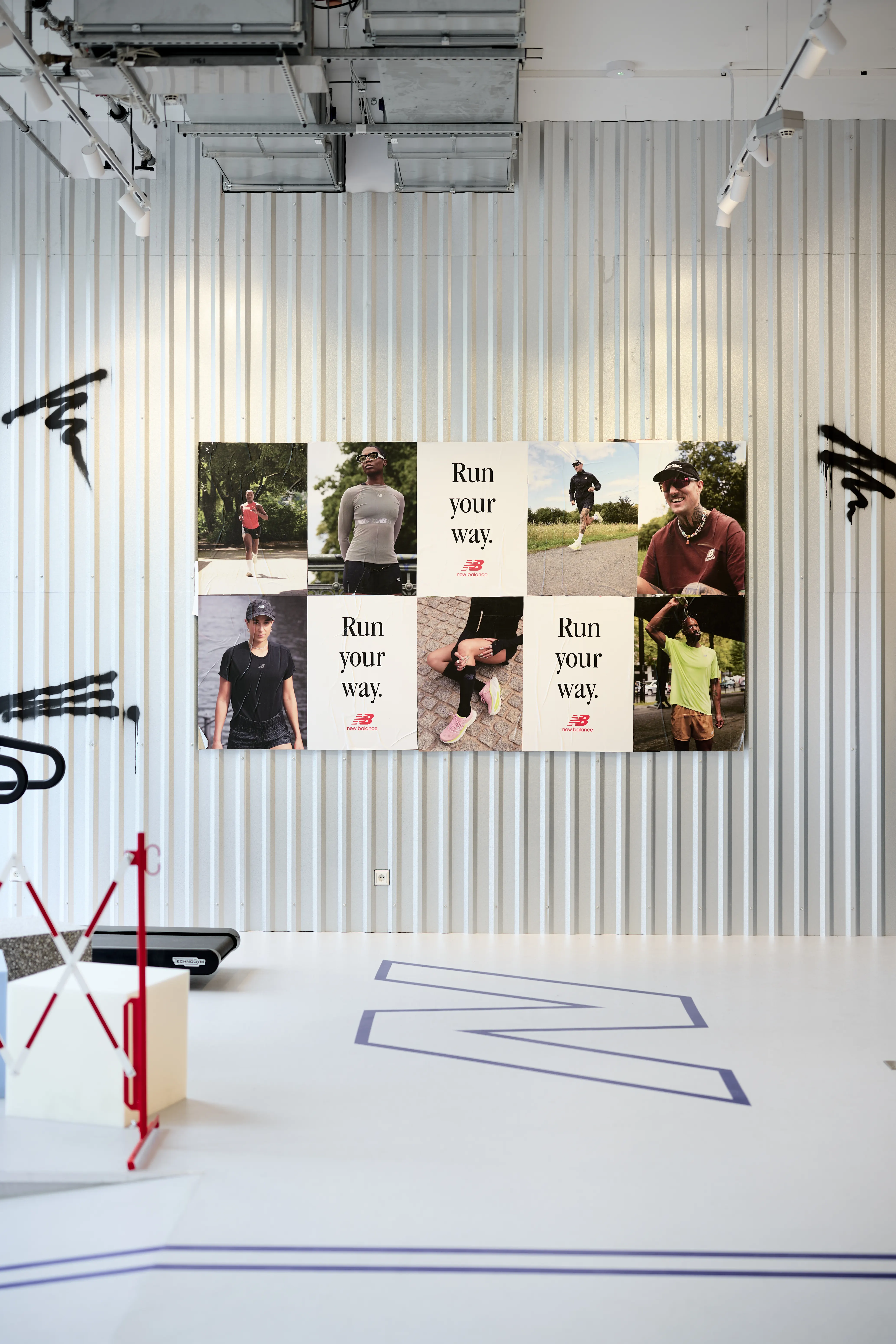 Run Your Way photo campaign wall on corrugated metal with spray-painted marks at the Highsnobiety x New Balance pop-up.