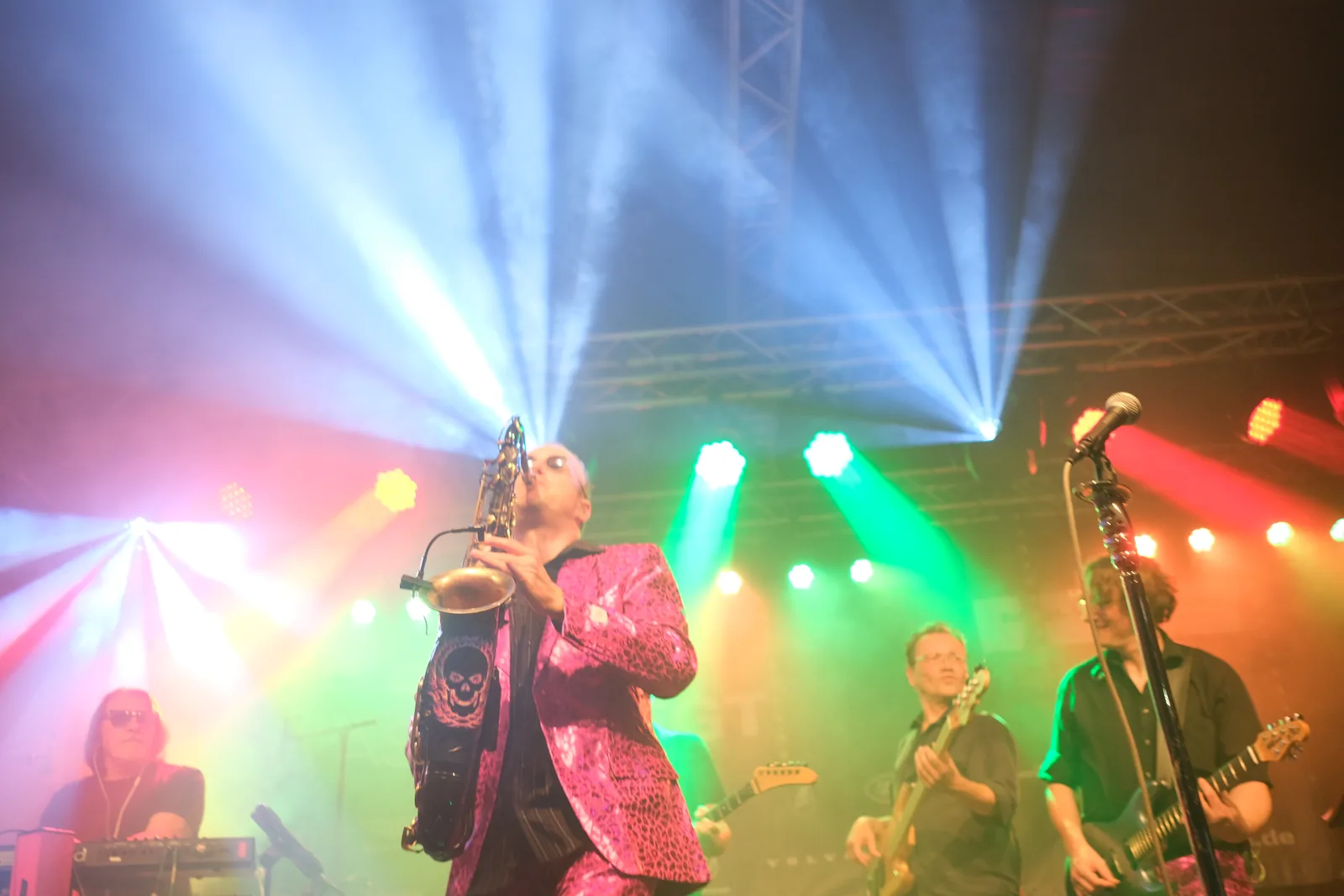 Band auf der Bühne im grünen und blauen Scheinwerferlicht.